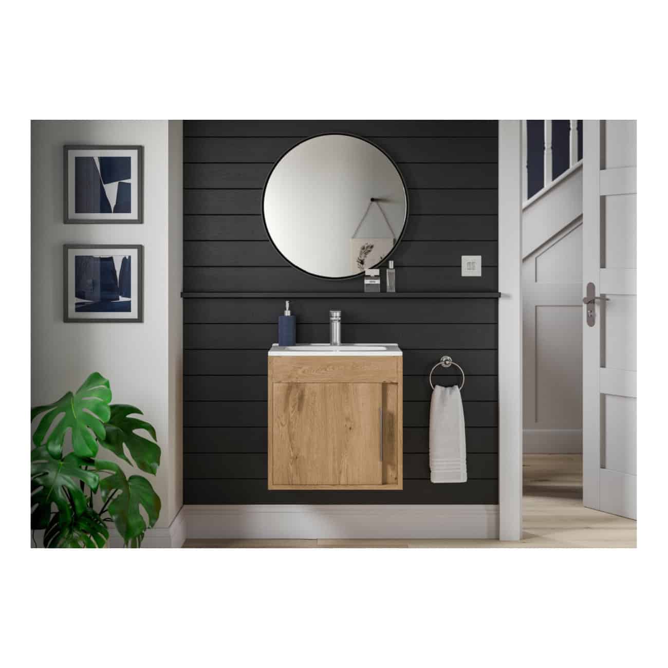 Contemporary bathroom vanity with wooden cabinet and round mirror, set against a black paneled wall. Features minimalist design with a potted plant and framed artwork creating a stylish, modern bathroom space.