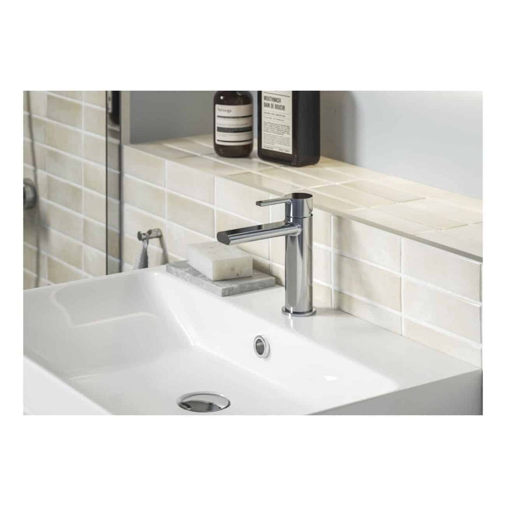 Shiny chrome bathroom sink tap with beige tiled backsplash and soap on a marble tray, modern clean design, ideal for contemporary bathroom renovation or renovation projects.