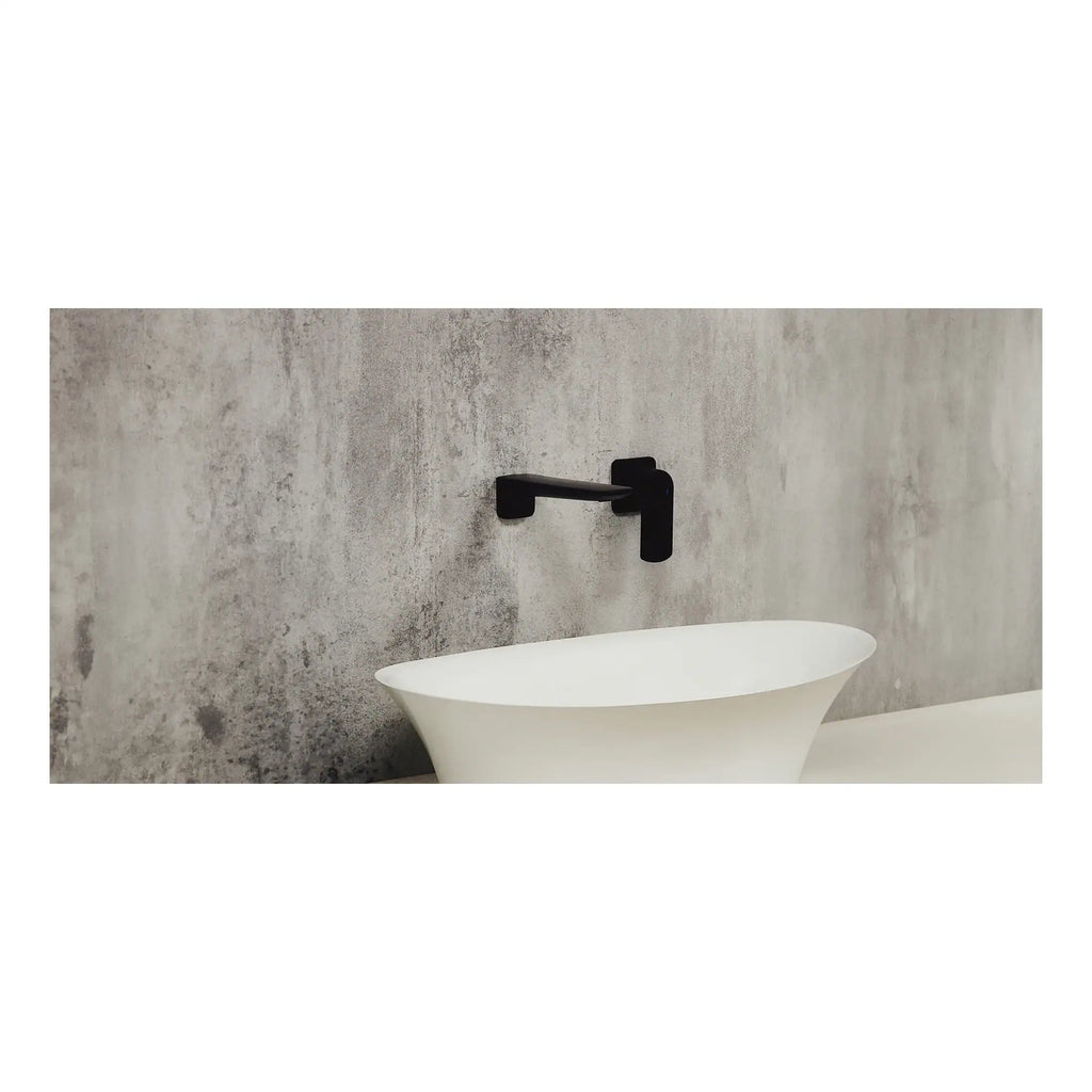 Modern freestanding white bathtub with sleek black wall-mounted faucet in a contemporary bathroom setting.