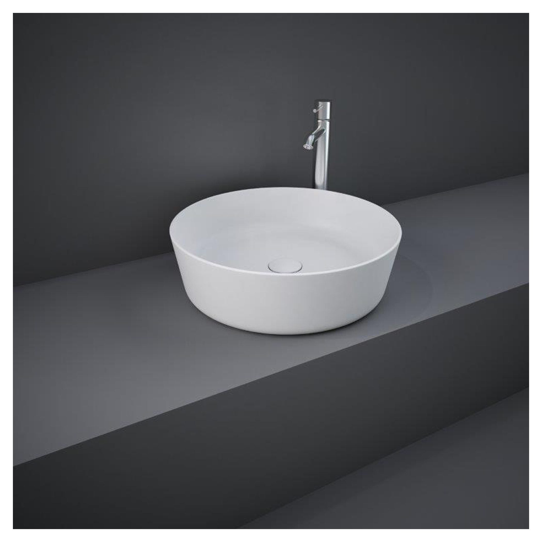 Sleek white vessel bathroom sink with chrome faucet on grey countertop and dark wall background, modern bathroom basin design.