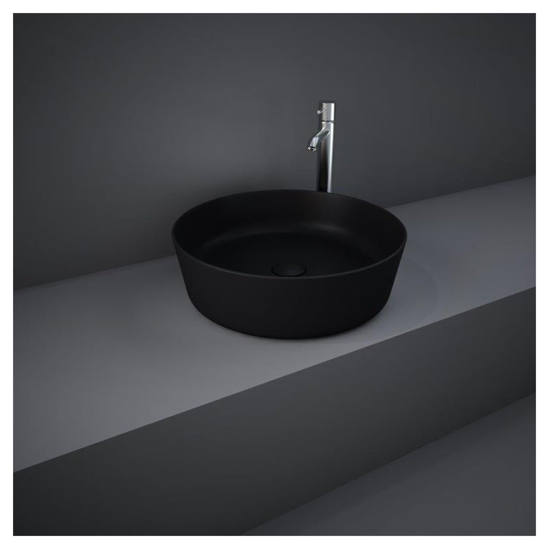 Contemporary black bathroom basin with silver faucet mounted on a sleek grey countertop, minimalist design for modern bathrooms.