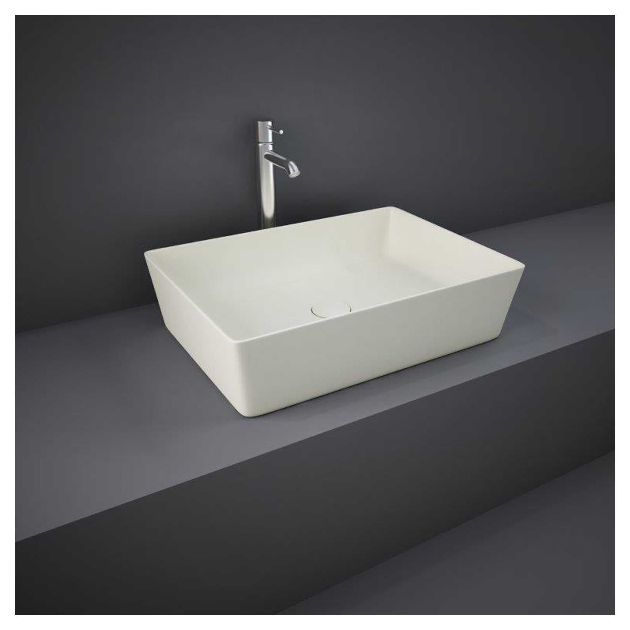 Sleek rectangular white bathroom basin with modern chrome tap, minimalist design on grey countertop against dark wall, perfect for contemporary bathrooms.