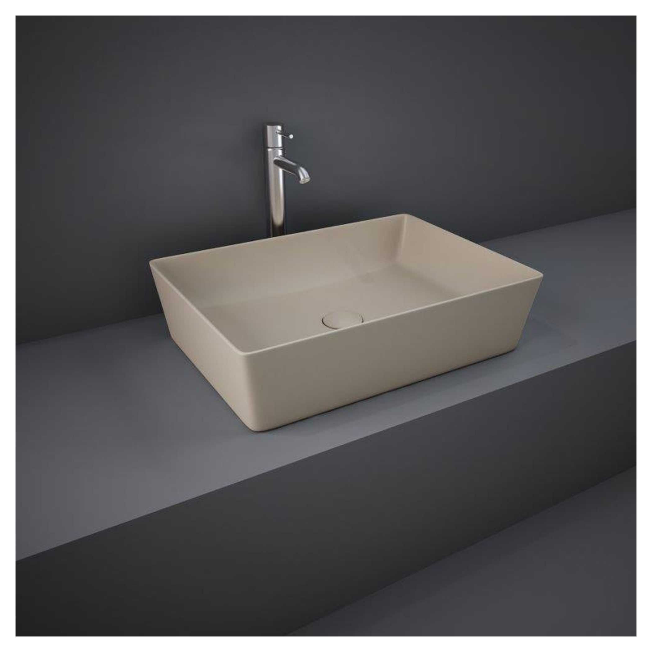 Sleek beige rectangular bathroom sink with modern chrome faucet on grey countertop against dark wall.
