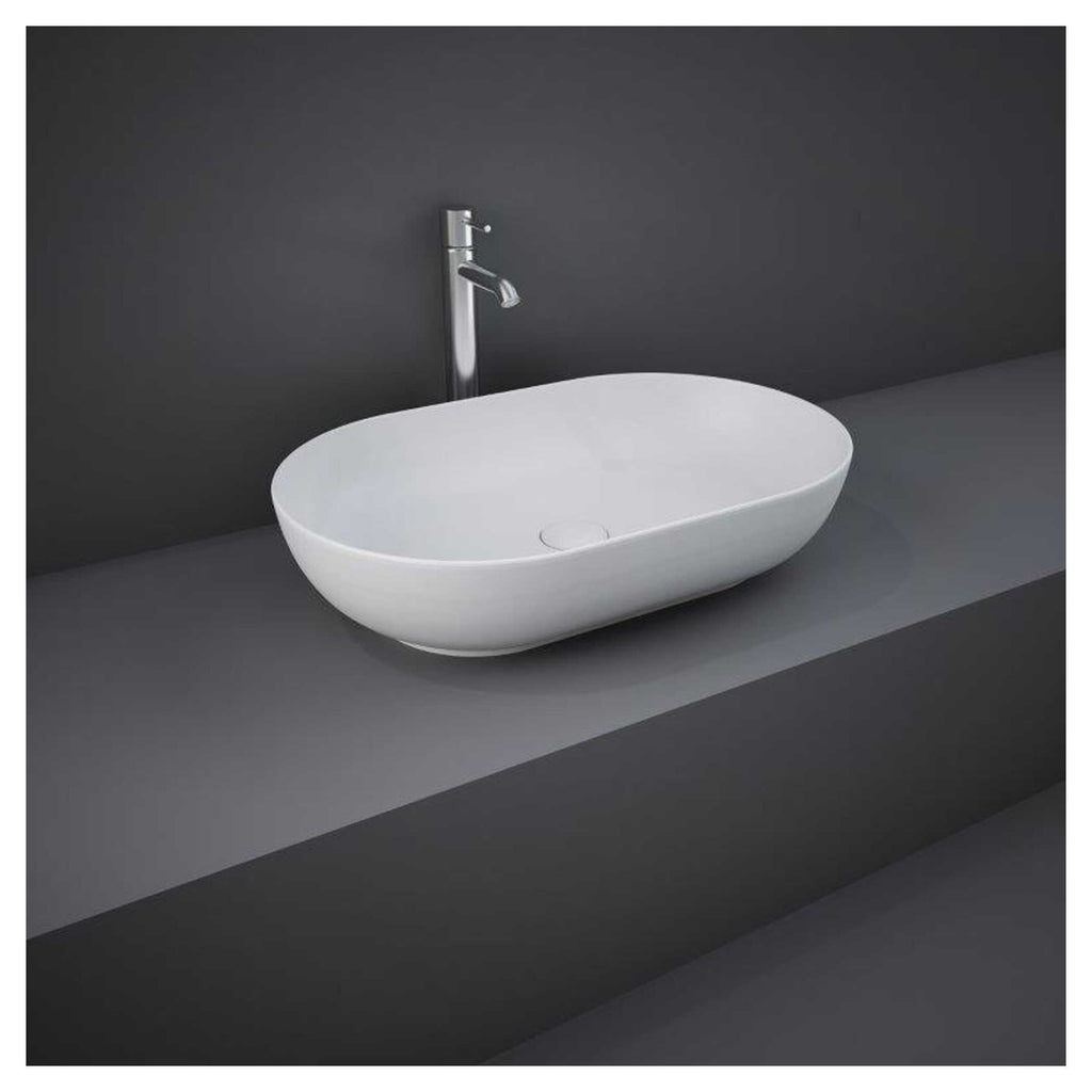Modern white vessel bathroom sink with chrome faucet on grey countertop in contemporary bathroom setting.