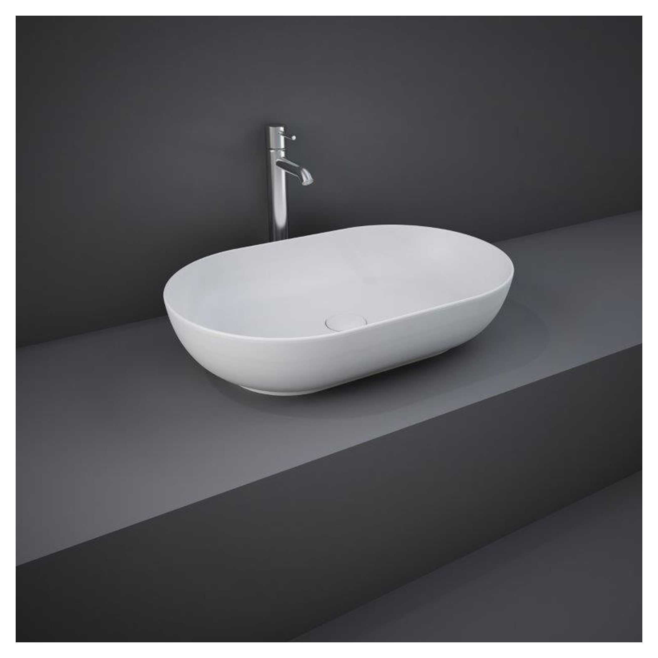 Modern white vessel bathroom sink with chrome faucet on grey countertop in contemporary bathroom setting.