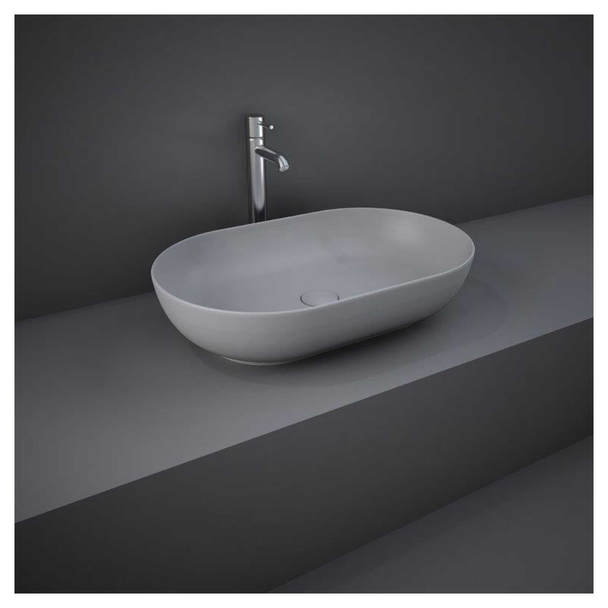 Sleek modern white countertop bathroom sink with chrome faucet on grey background.