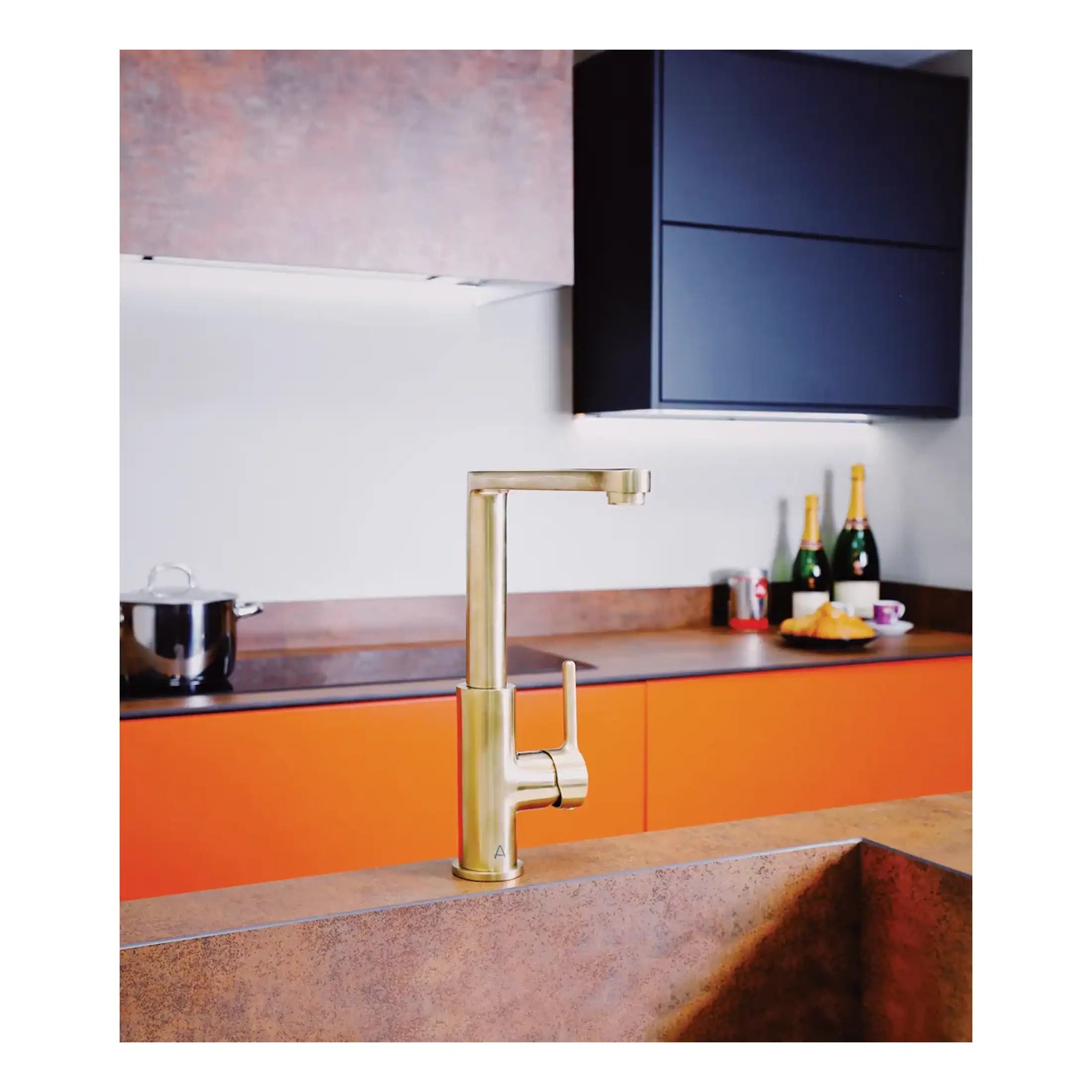 Sleek gold kitchen tap with modern design in contemporary kitchen setting featuring orange cabinets and navy wall-mounted storage. Perfect for stylish kitchen renovations.