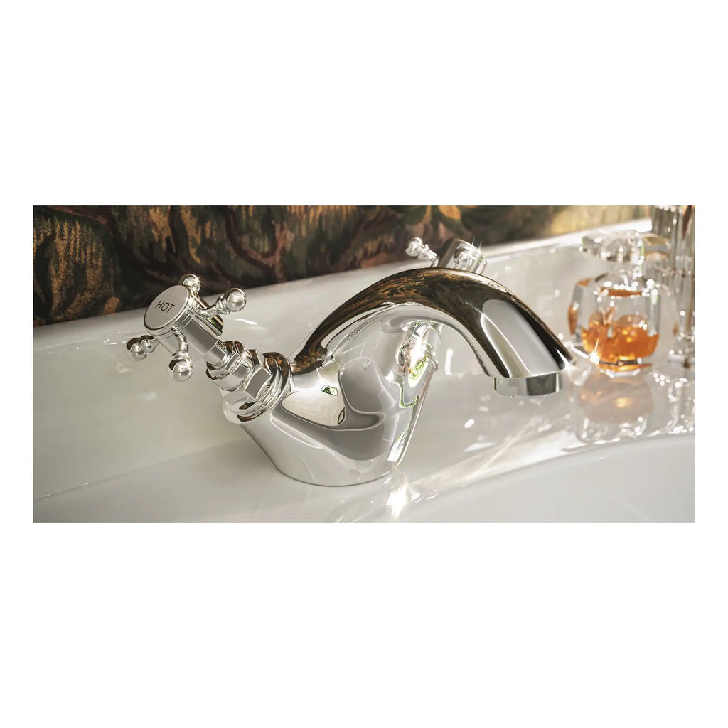 Shiny chrome bathroom tap with vintage-inspired design, mounted on a white bathtub with decorative toiletries in the background, showcasing luxurious bathroom fixtures and accessories.