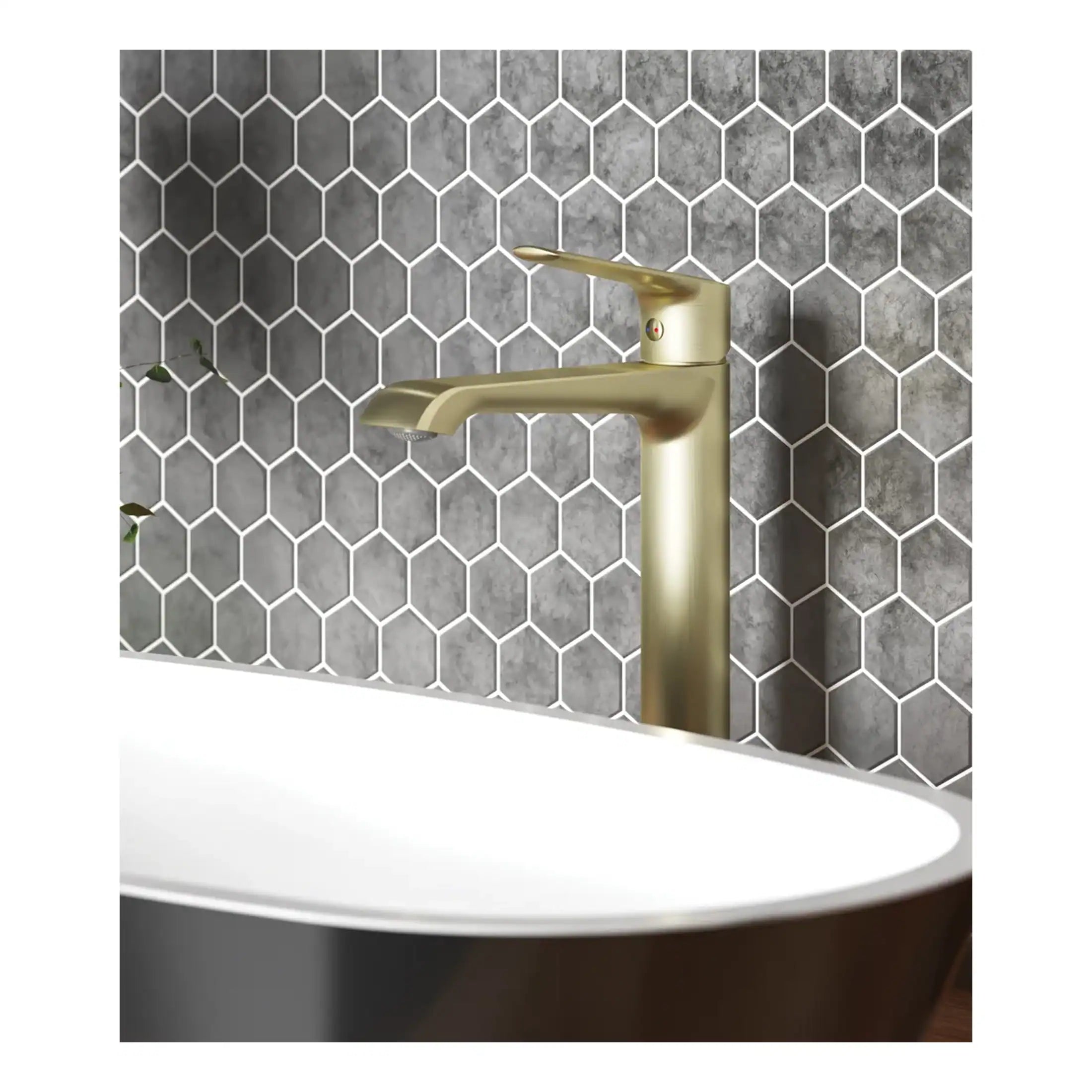 Sleek gold bathroom tap mounted above a modern white sink with a grey hexagonal tile backsplash. Luxurious bathroom design featuring contemporary fixtures and stylish tiling.
