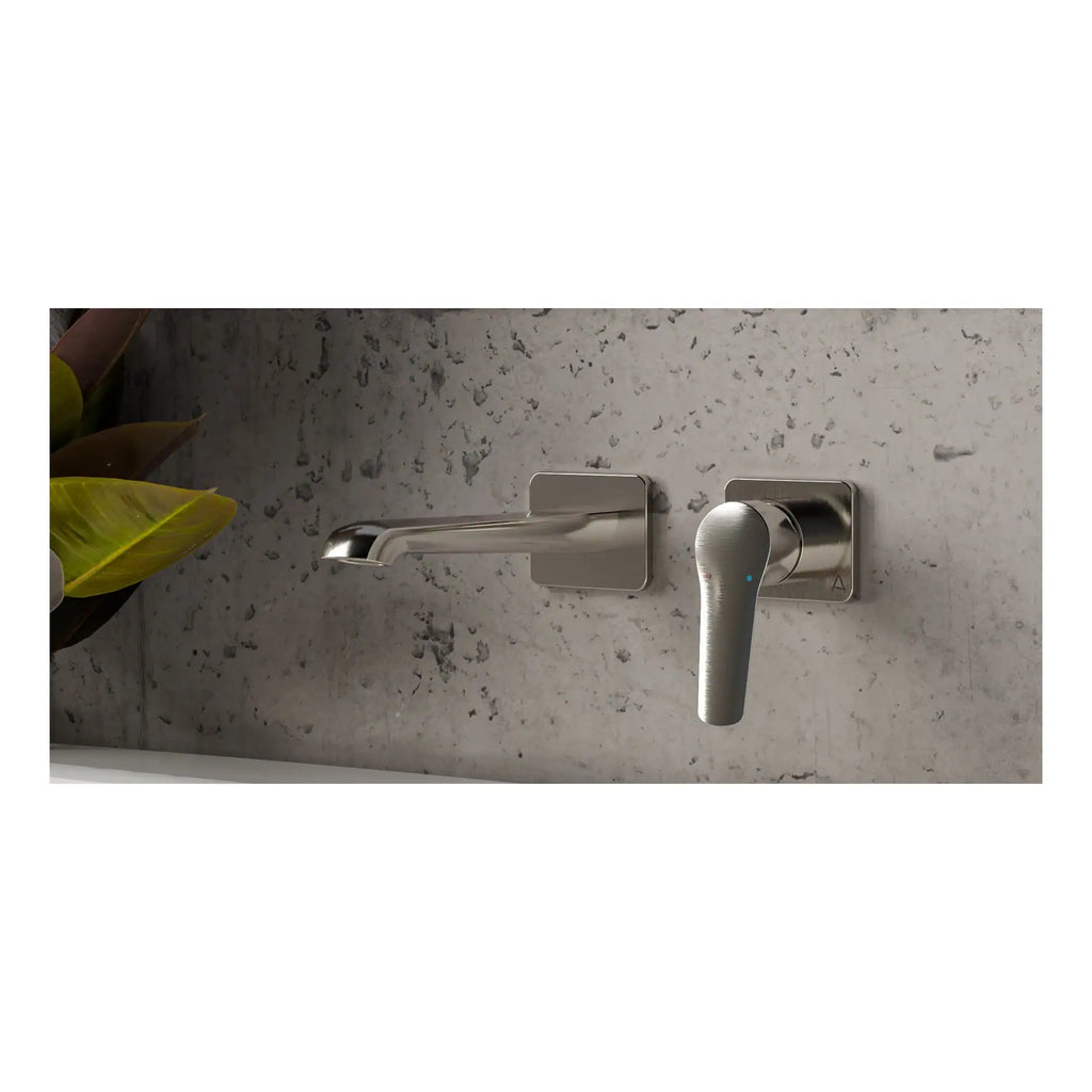 Modern brushed nickel bathroom faucet with touchless technology set on a textured grey stone sink counter.