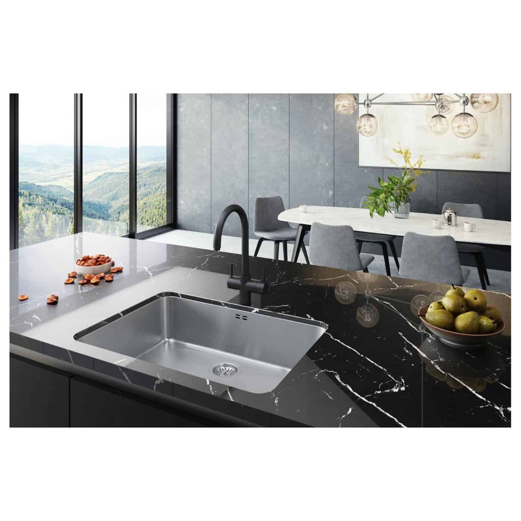 Shiny black marble kitchen countertop with a built-in stainless steel sink and modern black faucet, overlooking scenic mountain views through large windows, featuring contemporary dining space with grey chairs and elegant lighting.