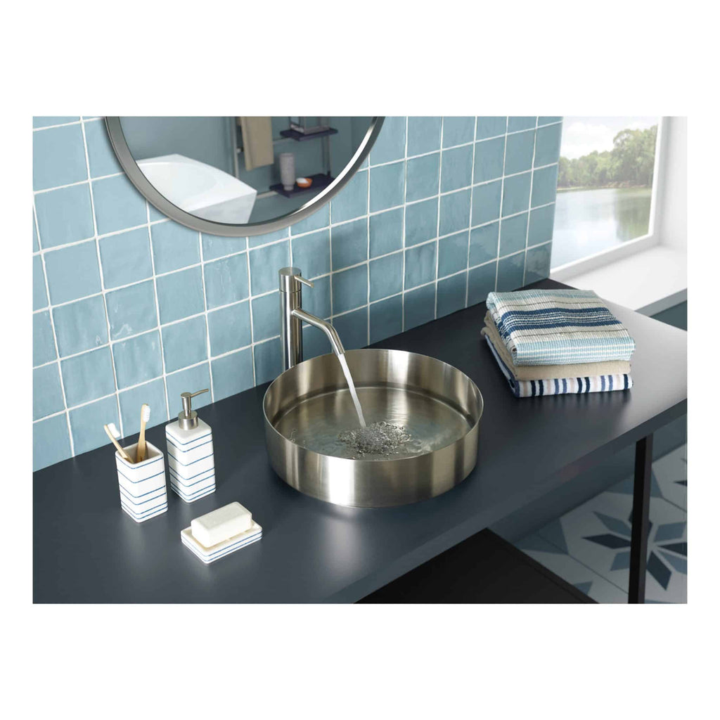 Brushed stainless steel bathroom sink with water running, modern black countertop, neatly folded blue and white towels, minimalist bathroom accessories, blue tiled wall, scenic window view in bathroom, stylish bathroom design, contemporary bathroom with elegant fixtures.