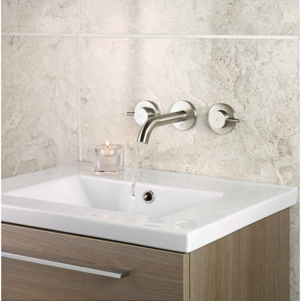Sleek modern bathroom sink with brushed metal tap and wall-mounted controls, perfect for contemporary bathroom designs and high-end renovations.