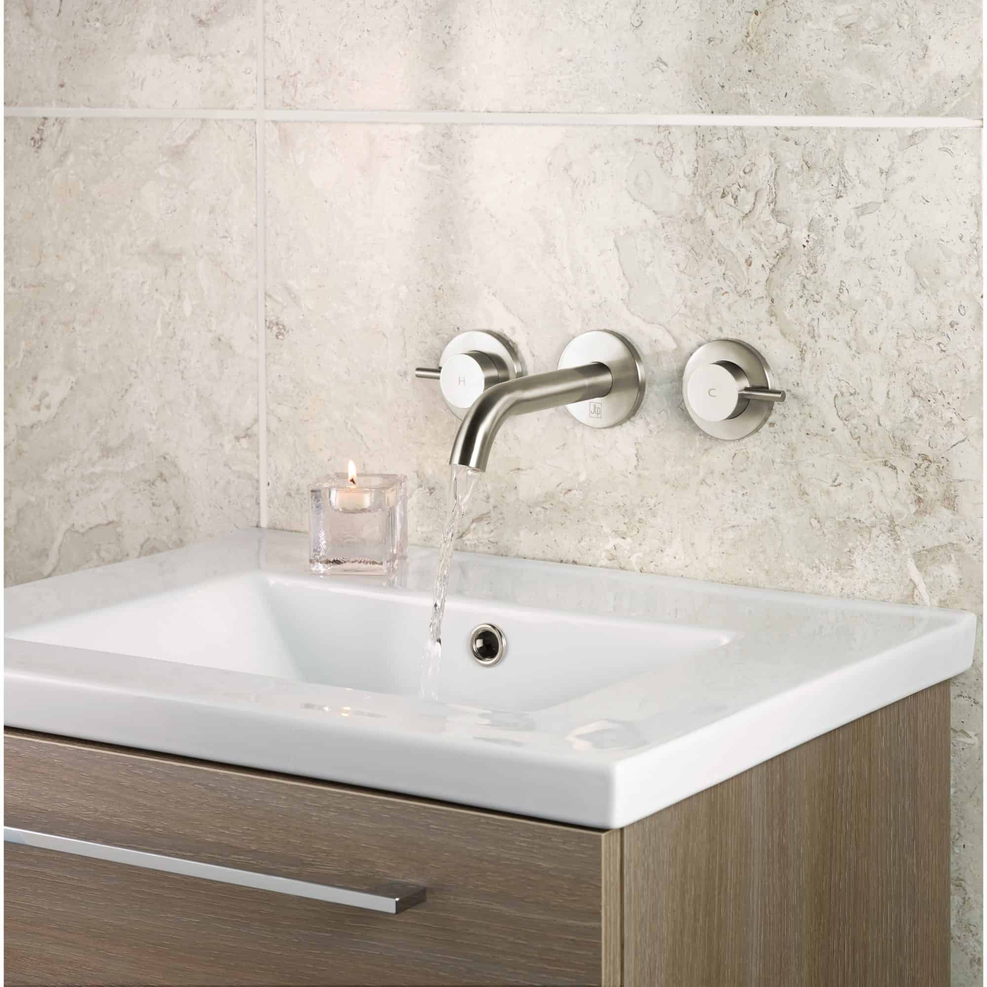 Sleek modern bathroom sink with brushed metal tap and wall-mounted controls, perfect for contemporary bathroom designs and high-end renovations.