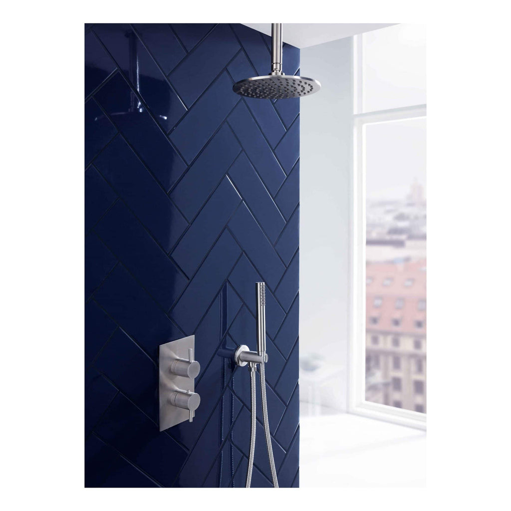 Shower head and mixer tap set in modern bathroom with dark blue tiled wall and large window, showcasing contemporary bathroom fixtures for luxury shower experiences.