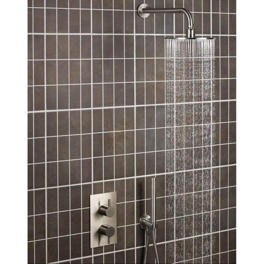 Shower area with modern rain shower head, wall-mounted controls, and handheld shower slider installed in a stylish bathroom with dark tile features.