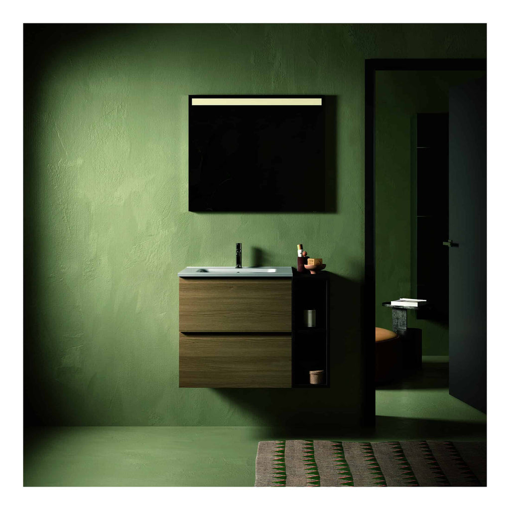 Sleek modern bathroom vanity with a black basin and wooden cabinet against a textured green wall, complemented by stylish bathroom accessories and a partially open door leading to a toilet area.