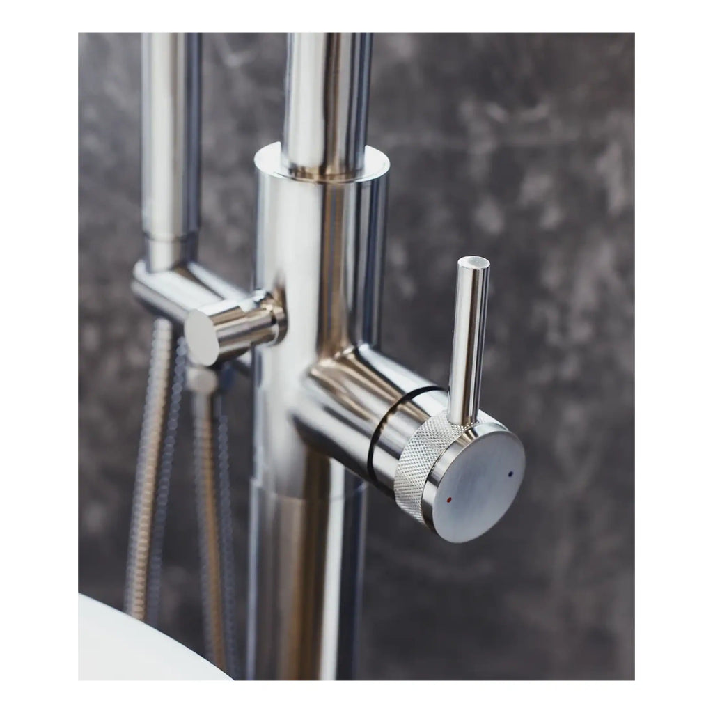 Shiny chrome bathroom mixer tap with control handle on a modern wet room wall, featuring sleek design elements and a black background for contemporary bathroom decor.