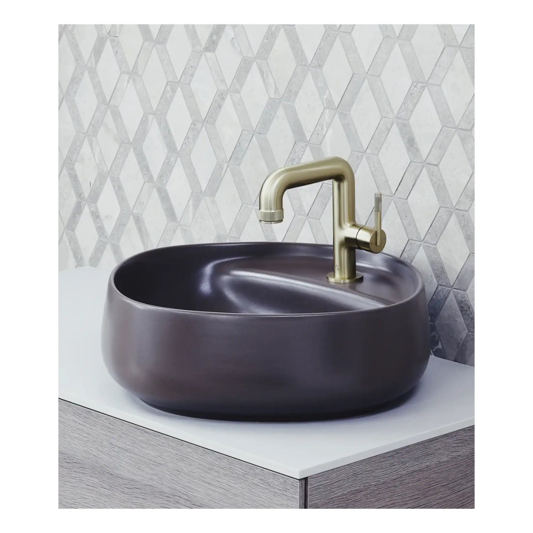 Sleek black bathroom sink with gold faucet set against a geometric tile background, showcasing modern and stylish bathroom design. Perfect for contemporary bathroom renovation.