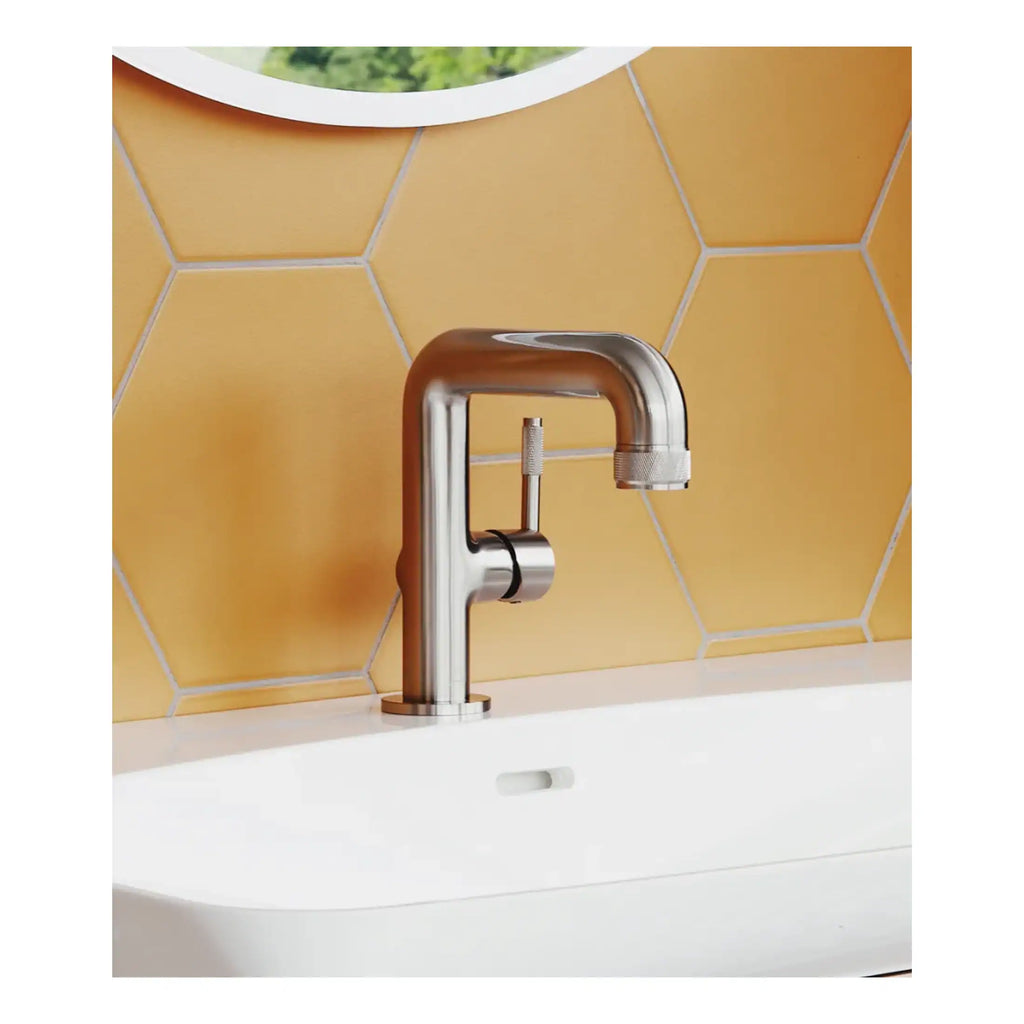 Brushed stainless steel bathroom tap with modern design on a yellow tiled wall for stylish washbasin setup.