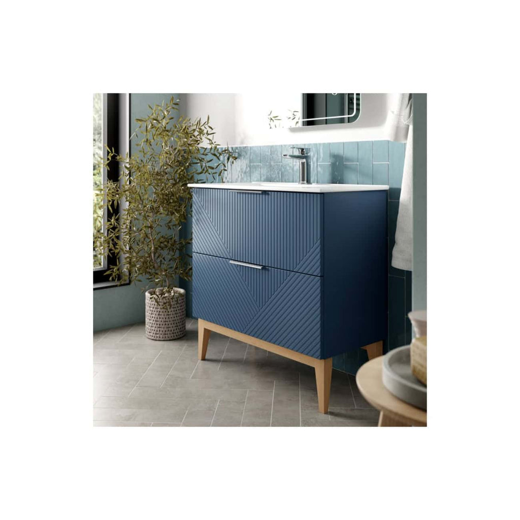 Sleek blue bathroom vanity with textured geometric front panel and wooden legs in a contemporary bathroom setting. Perfect for modern bathroom storage and design.