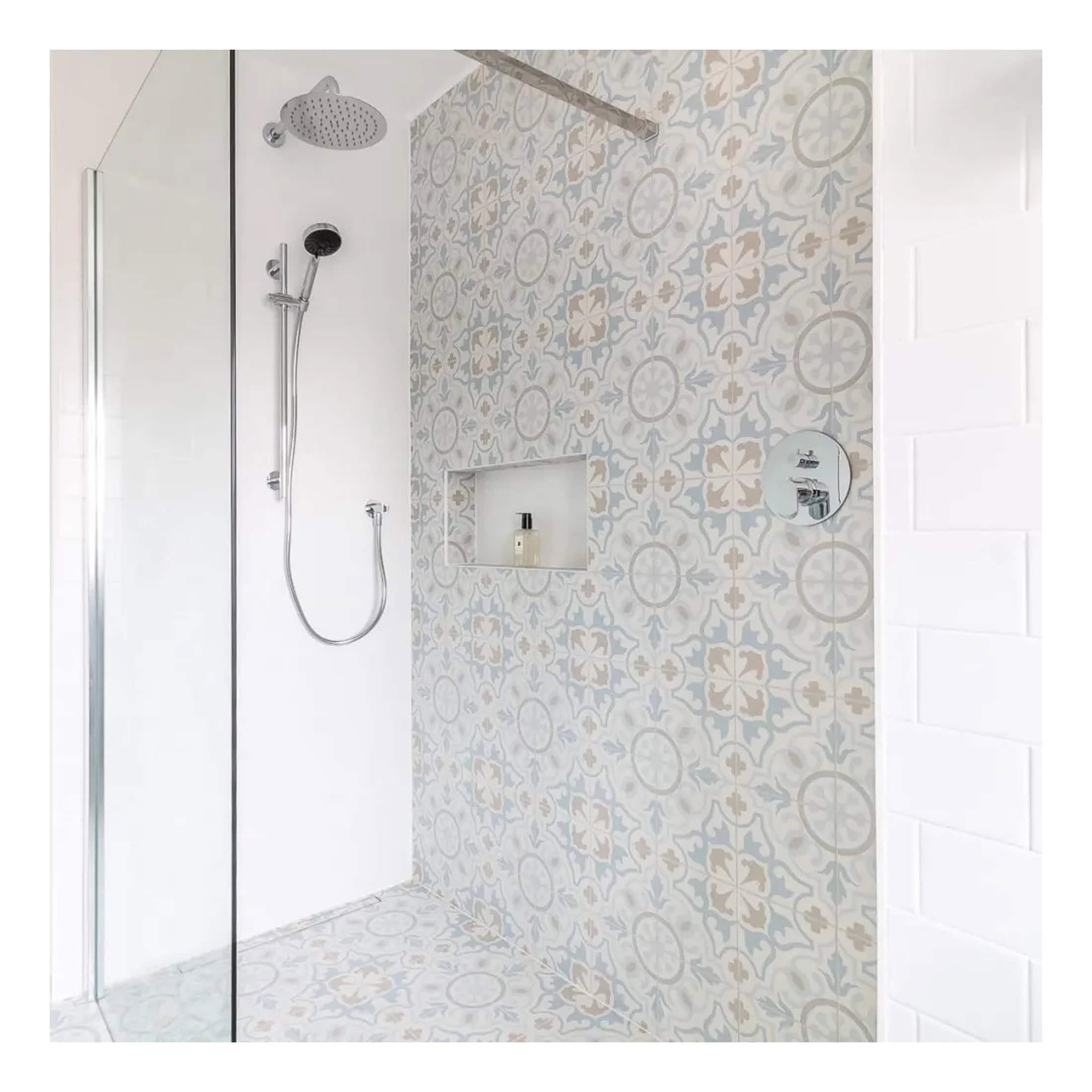 Modern walk-in shower with patterned tile wall, dual shower heads, and minimalist design for luxury bathroom renovation.