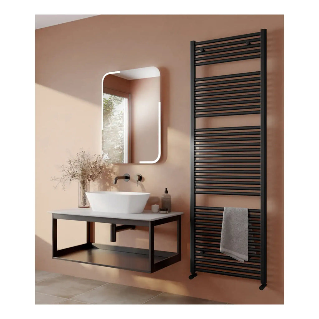 Sleek black towel radiator and modern floating sink vanity in a contemporary bathroom setting. Featuring a stylish mirror with LED lighting and a window with natural light for a bright, minimalist design.