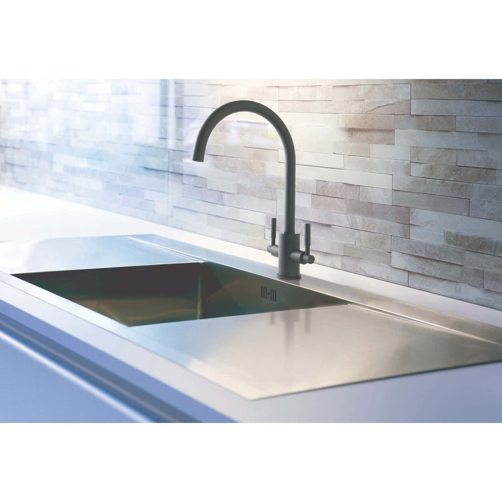 Sleek modern kitchen sink with stainless steel finish and black faucet, set against a textured light stone wall, perfect for contemporary bathroom or kitchen renovations.