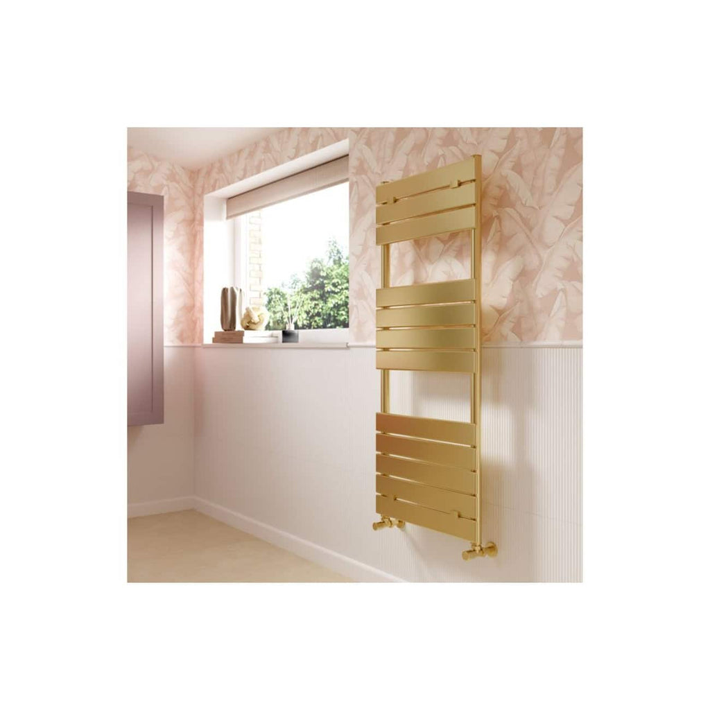 Sleek gold bathroom radiator mounted on a pastel pink wall with floral wallpaper, complemented by a window sill with decorative vases and plants, offering a modern and elegant bathroom heating solution.