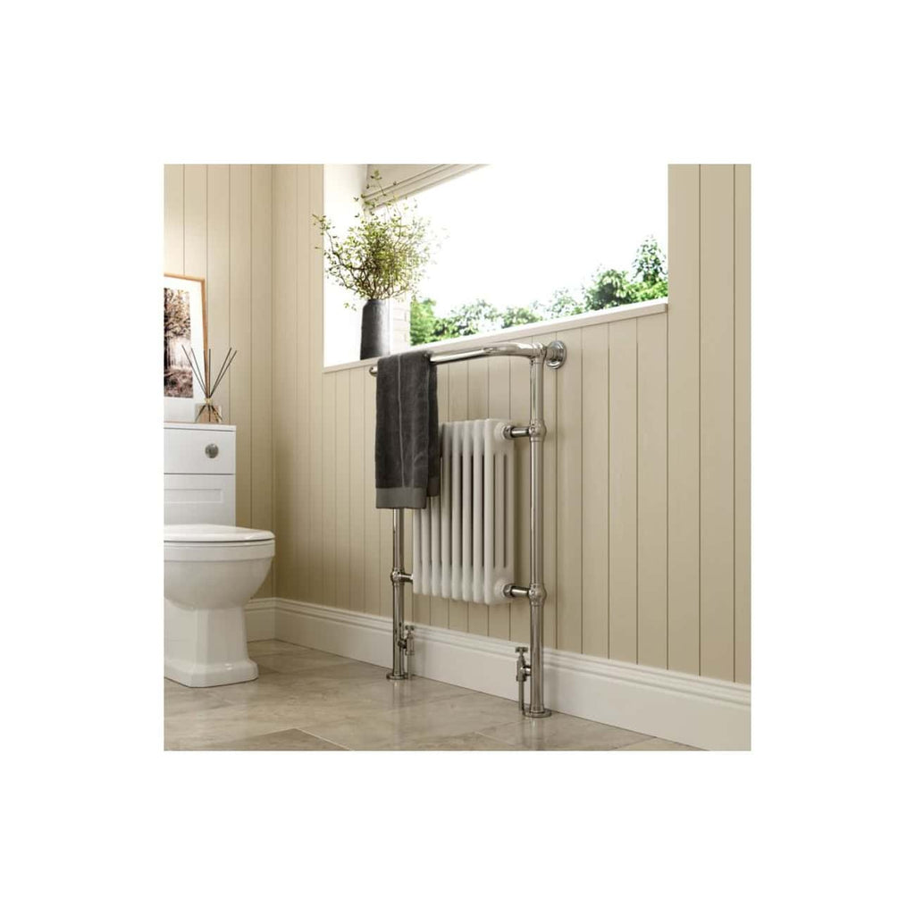 Radiator towel rail with grey towel in modern bathroom featuring beige wall paneling and window view of greenery.