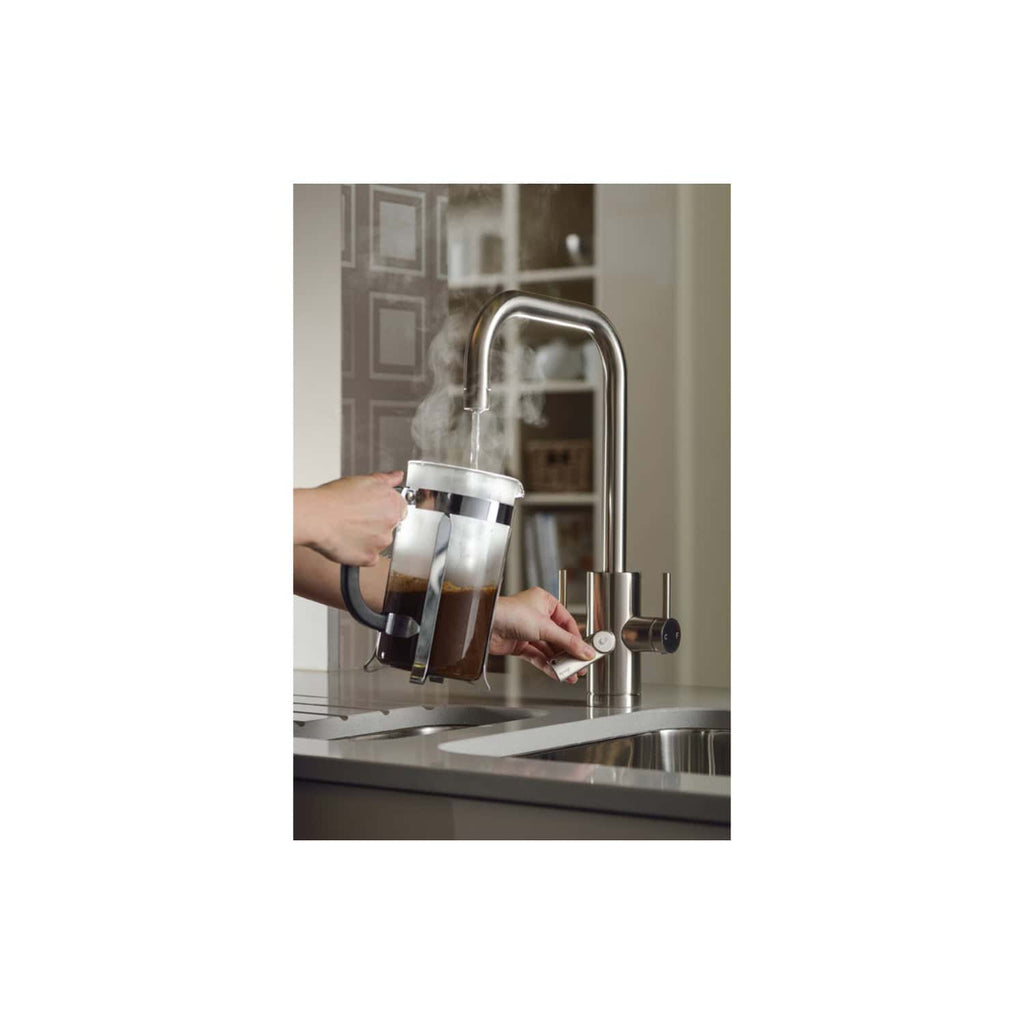 Filling a steaming cup of coffee from a modern kitchen tap with a built-in water filter, showcasing Bubly Bathrooms' sleek design and high-quality kitchen fixtures in a contemporary home setting.