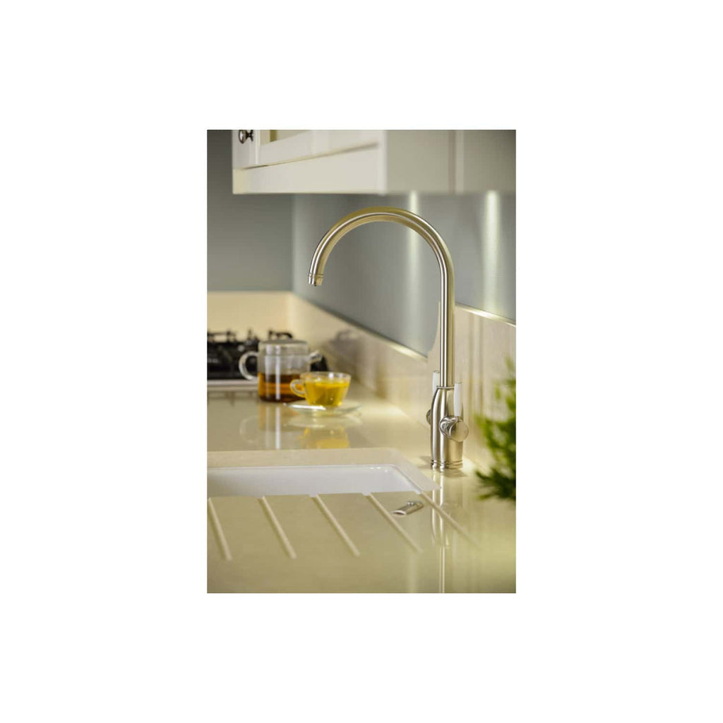 Sleek modern kitchen sink with stainless steel tap in a contemporary kitchen setting, featuring cream countertops and tea cups in the background, highlighting functional and stylish kitchen design.