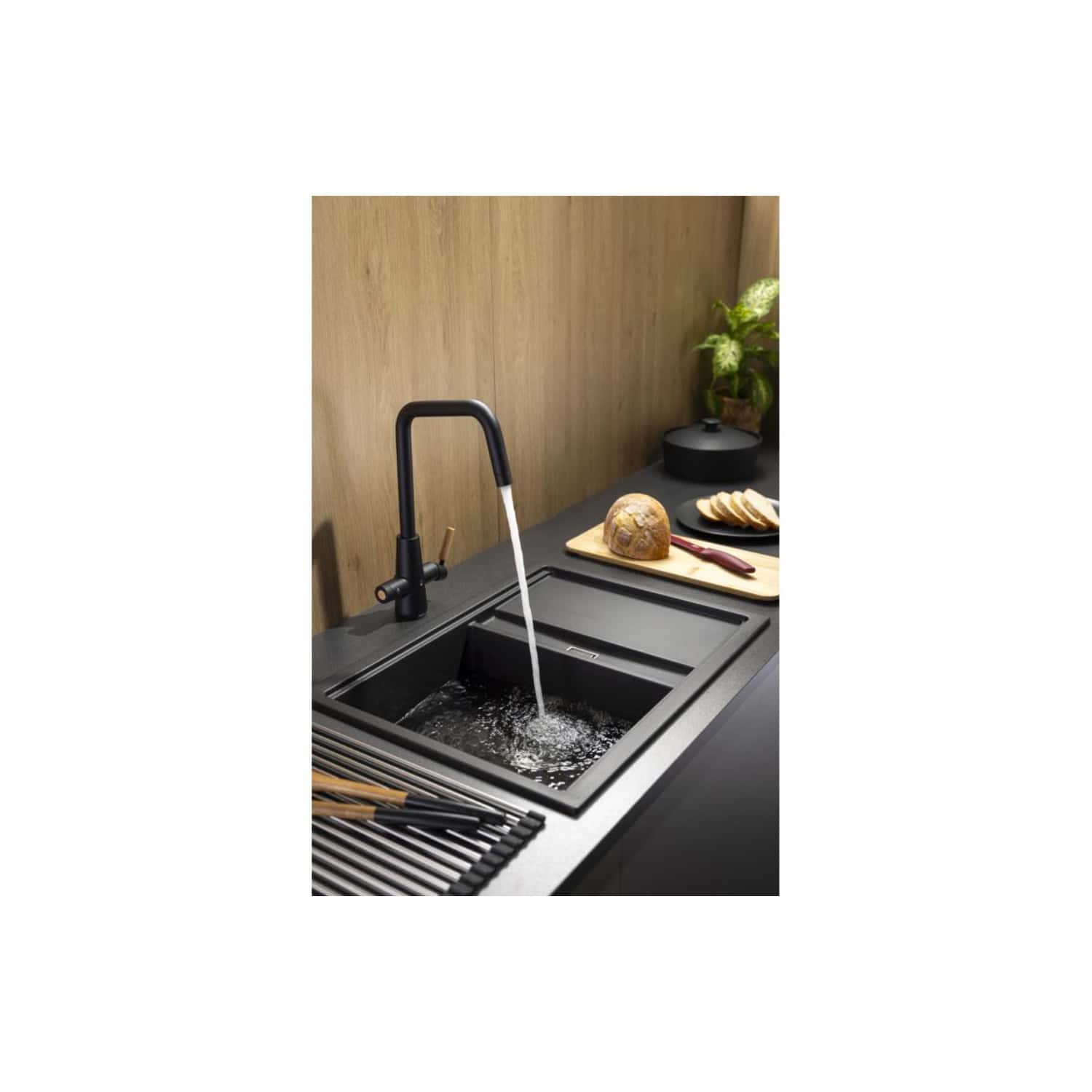 Sleek black kitchen sink with modern matte finish, fitted with a minimalist black pull-down tap, surrounded by a contemporary black countertop and wooden backsplash, creating a stylish and functional kitchen space.
