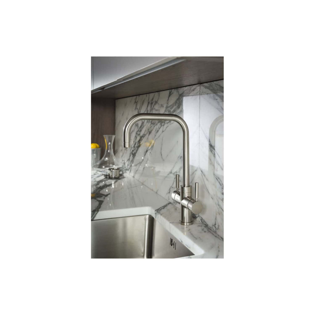 Sleek modern stainless steel kitchen faucet installed on a marble countertop with a matching marble backsplash, creating a luxurious and functional kitchen space.