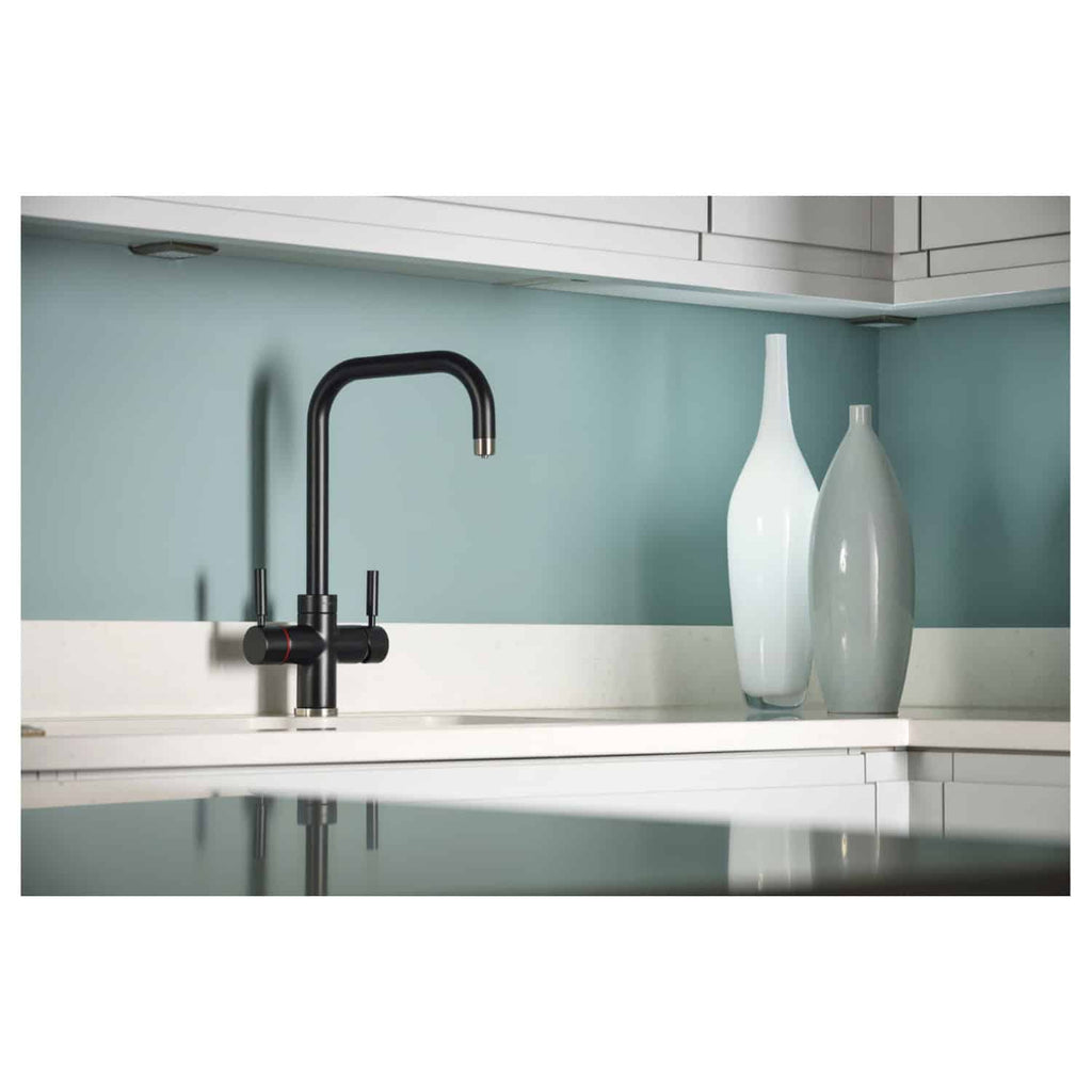 Sleek black kitchen tap with modern design, paired with decorative vases on a white countertop in a contemporary bathroom or kitchen setting.