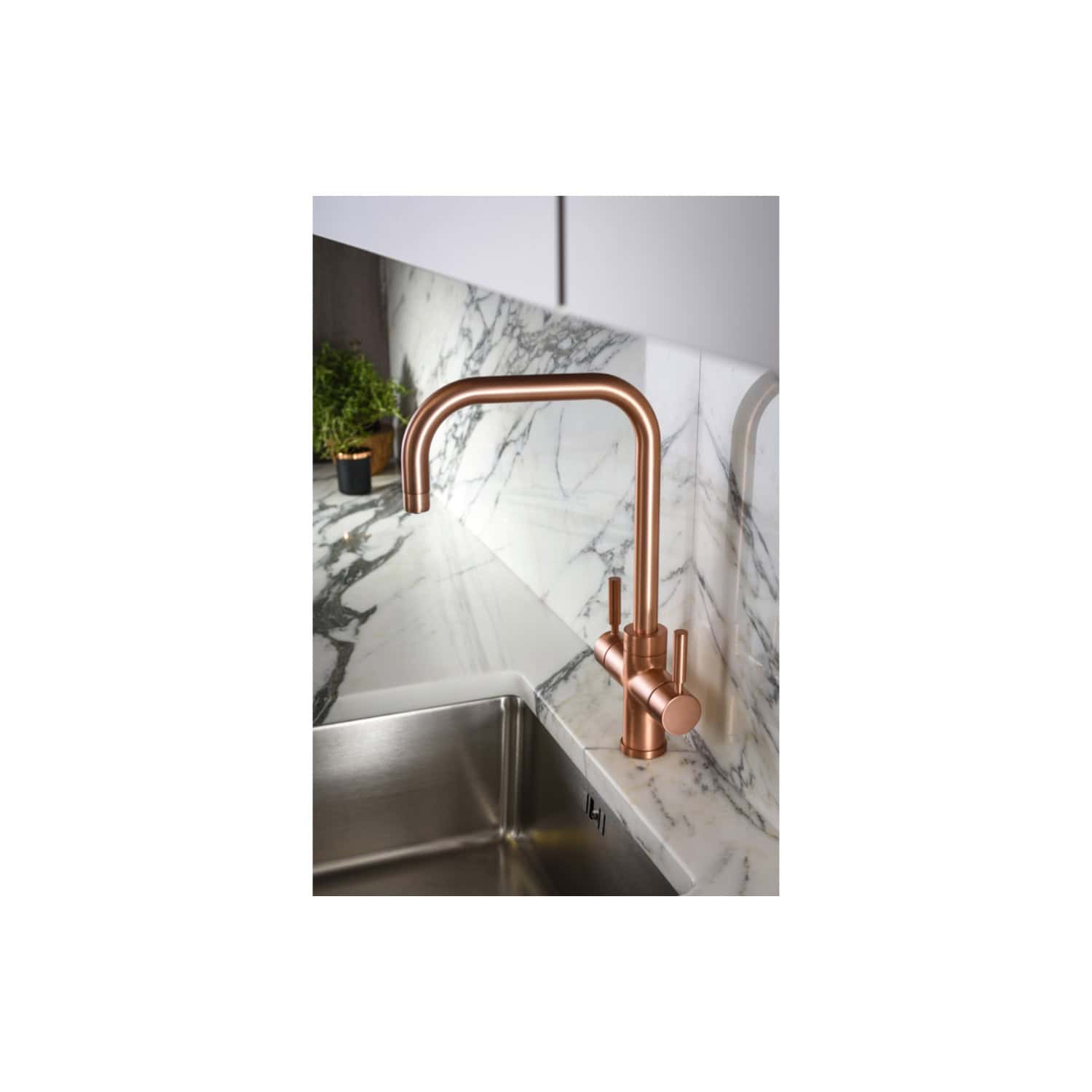 Sleek rose gold kitchen tap with modern design, high-arc spout, and single lever, installed over a stainless steel sink with a marble countertop and backsplash, perfect for contemporary bathrooms.