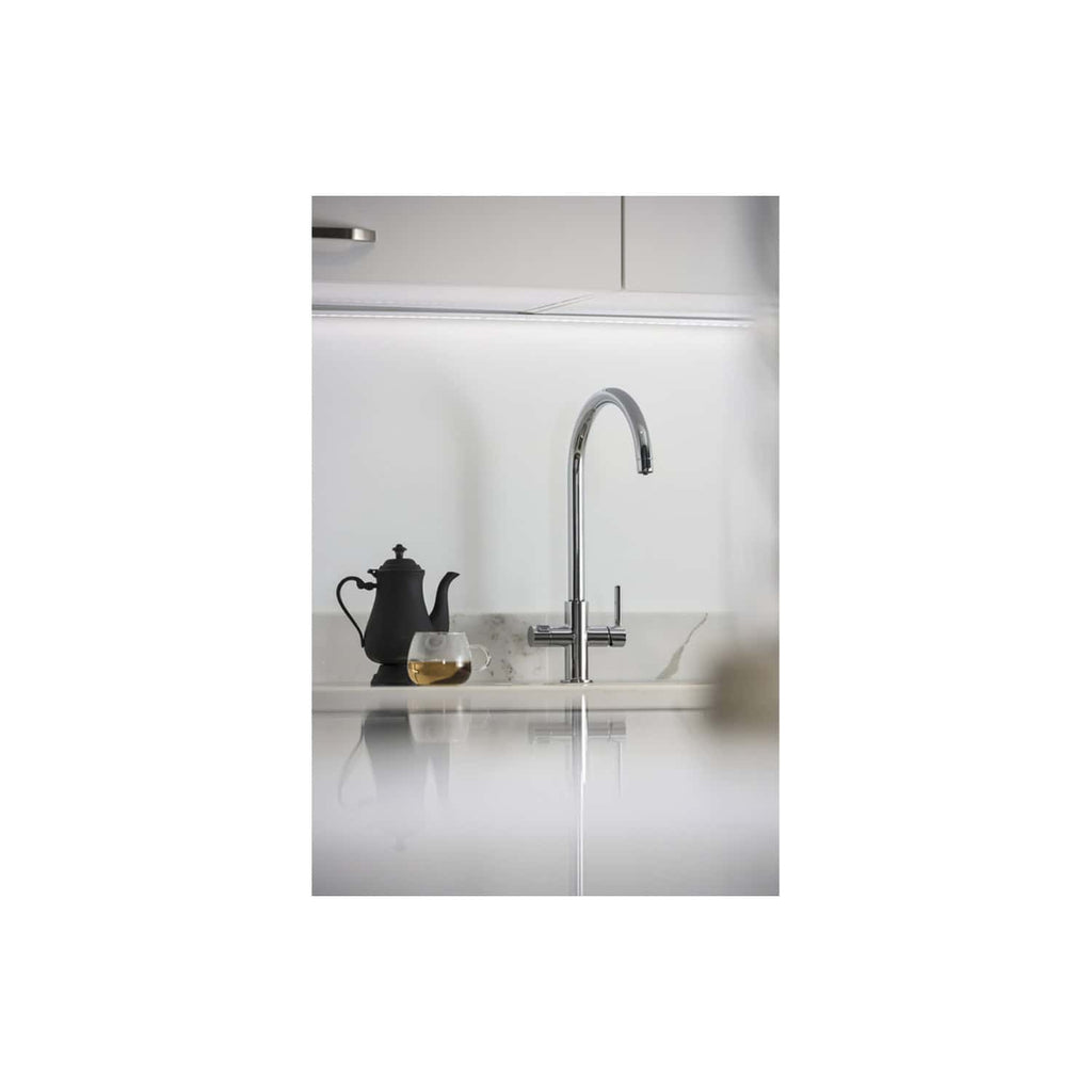 Modern kitchen sink with sleek chrome tap and tea set in minimalist style.