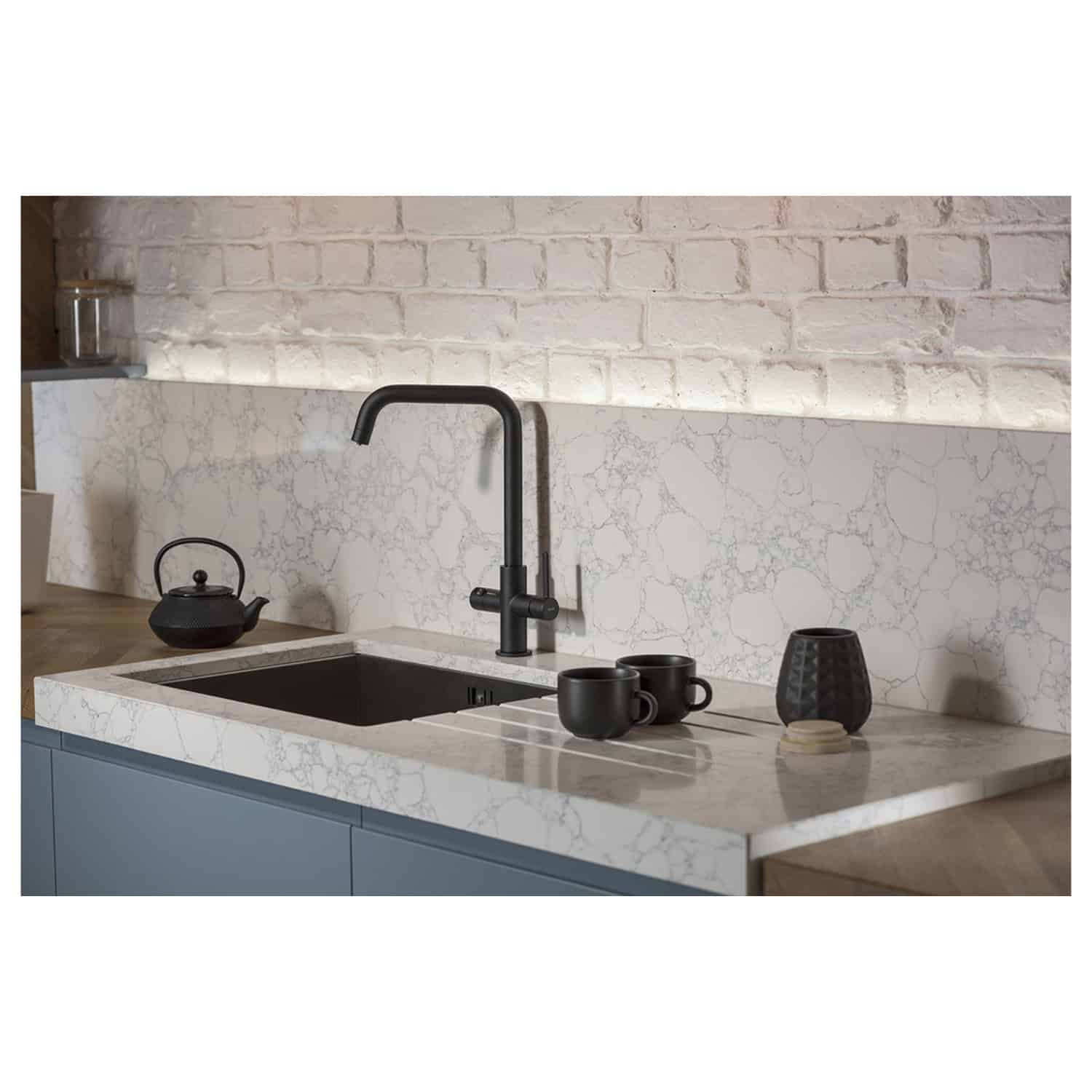 Sleek modern kitchen with marble worktop, black faucet, and minimalist decor, showcasing high-quality Bubly Bathrooms kitchen fixtures and fittings.