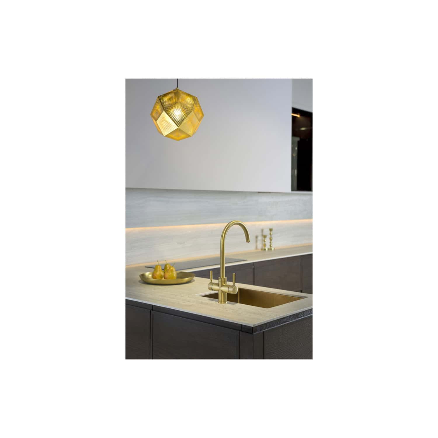 Shiny gold kitchen sink and faucet with elegant modern design, under warm decorative pendant lighting in contemporary kitchen, luxury kitchen design, matching gold accents, stylish minimalism, Bubly Bathrooms.