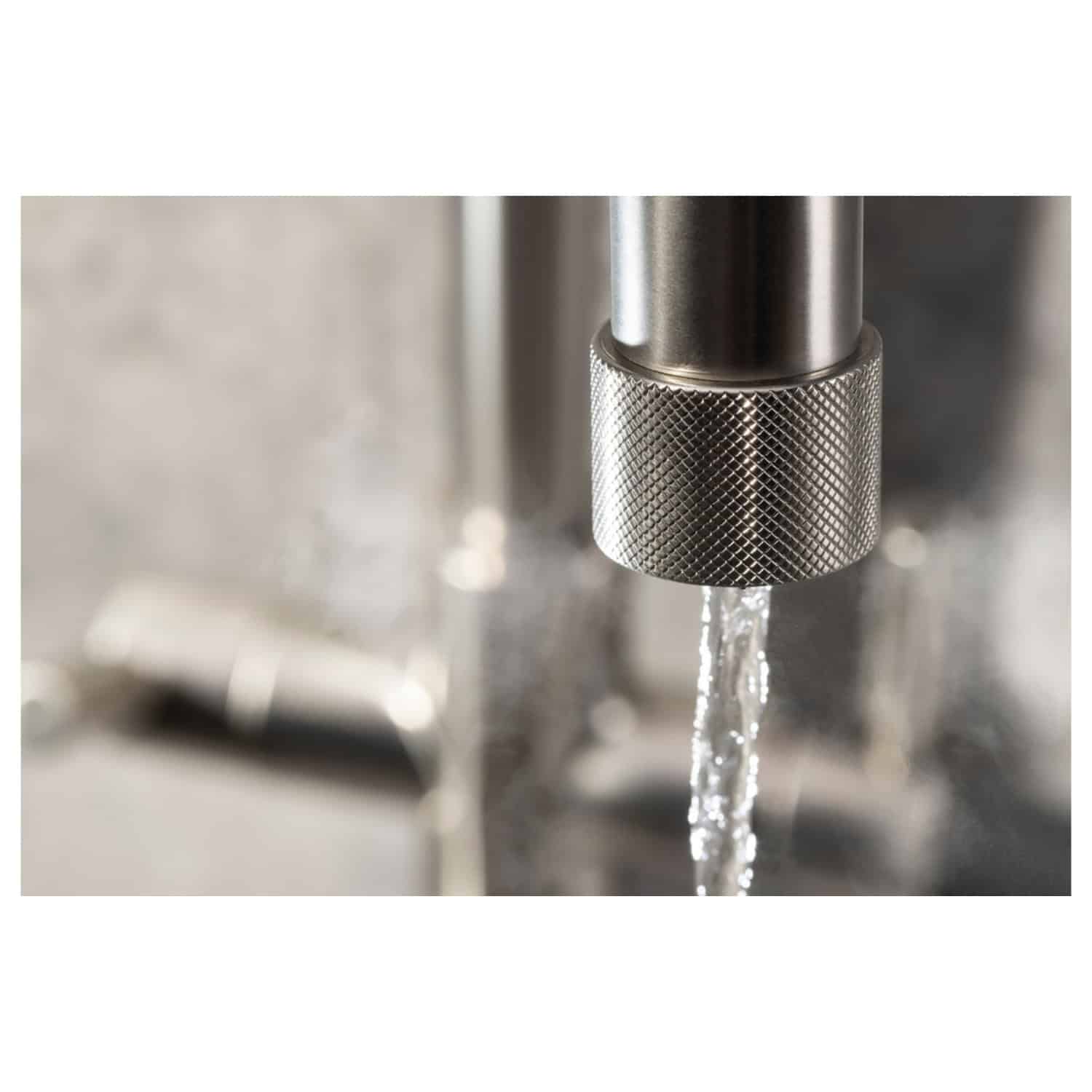 Shiny stainless steel kitchen tap with a water stream flowing, modern plumbing fixture for bathrooms or kitchens. High-quality bathroom and kitchen fittings from Bubly Bathrooms.