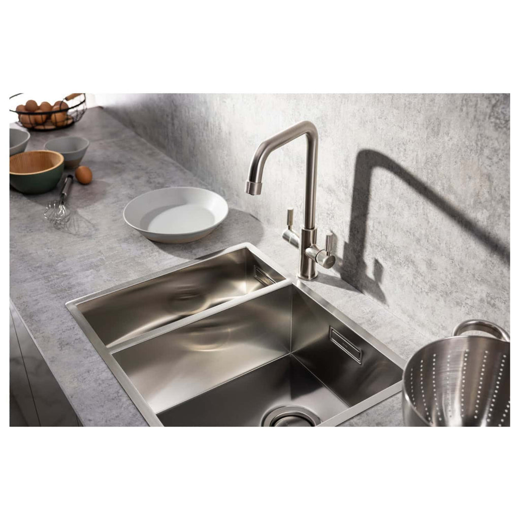 Stainless steel kitchen sink with modern design, adjacent to grey marble countertop and kitchen utensils, ideal for contemporary bathroom or kitchen renovation projects.