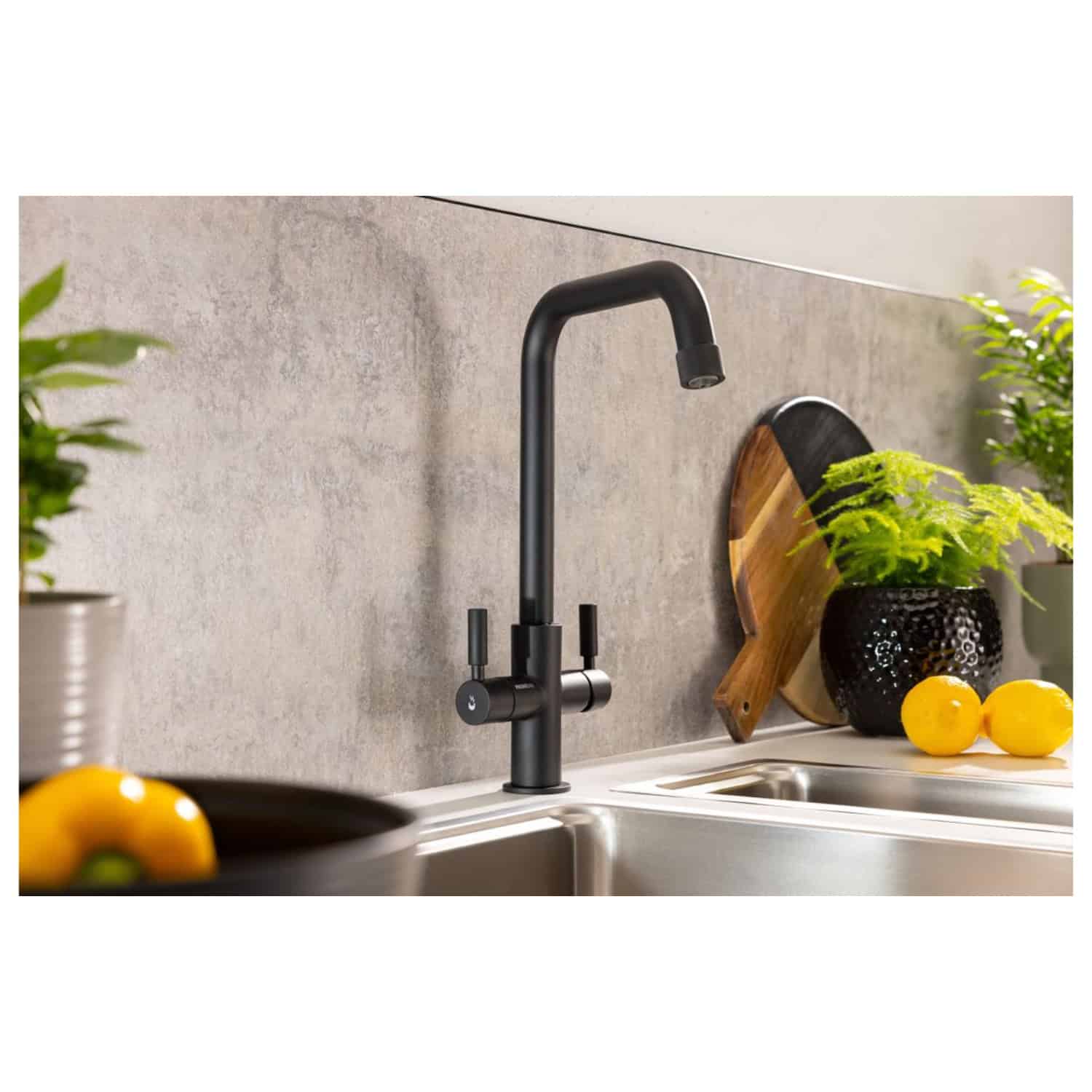 Sleek black modern kitchen sink tap with high-arc design, perfect for contemporary kitchens, complemented by wooden and black decorative items, with fresh plants and lemons for a stylish look.