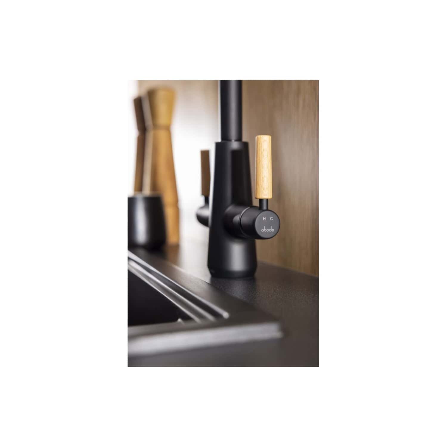 Black kitchen tap with wooden handles and modern design, featuring easy-to-use temperature controls, ideal for stylish and functional bathrooms or kitchens.