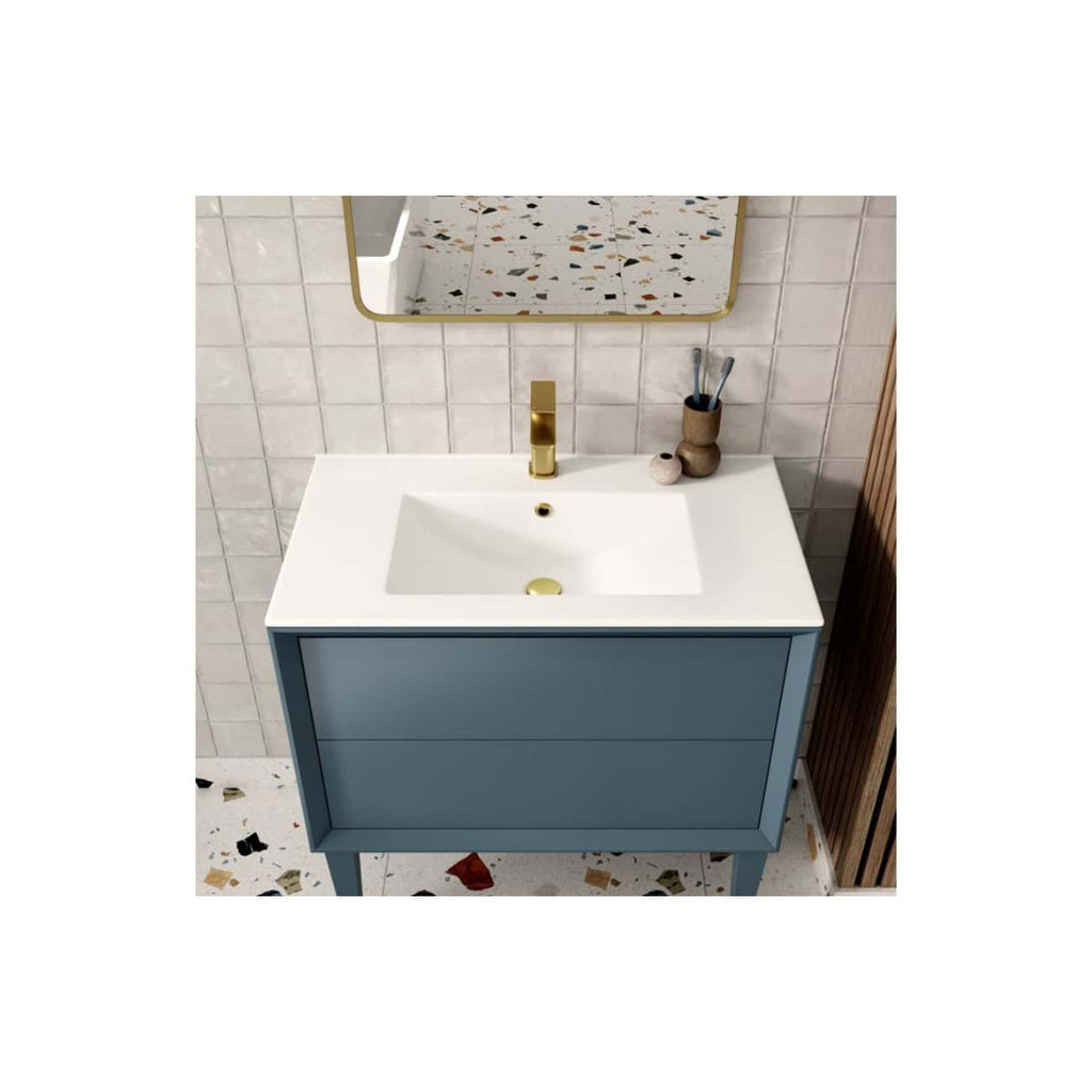 Sleek blue bathroom vanity with white countertop and integrated sink featuring a gold faucet, set against a terrazzo floor and tiled wall, styled for modern bathroom décor.