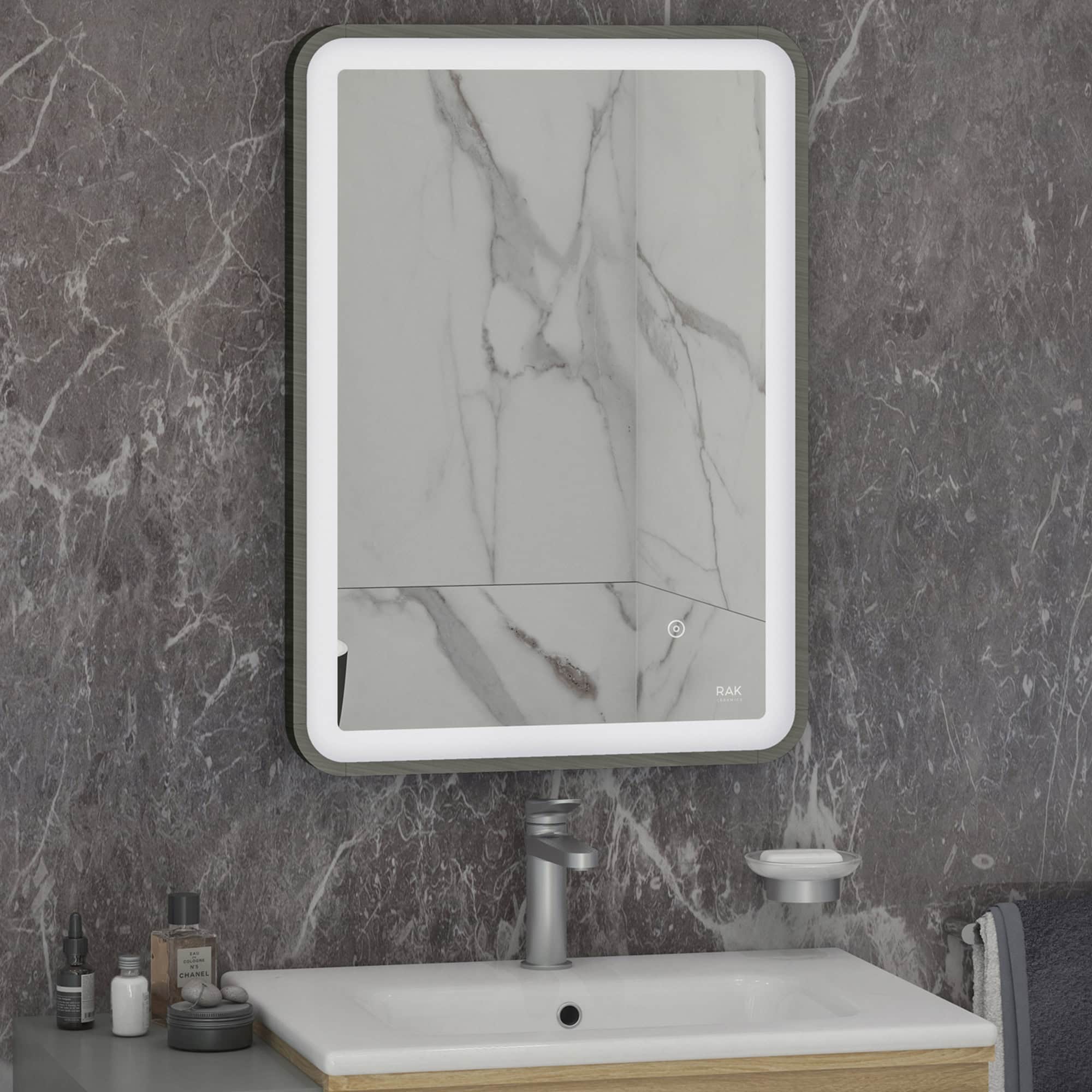 Chrome framed illuminated bathroom mirror with marble wall background and modern sink, showcasing elegant and functional bathroom design elements by Bubly Bathrooms.