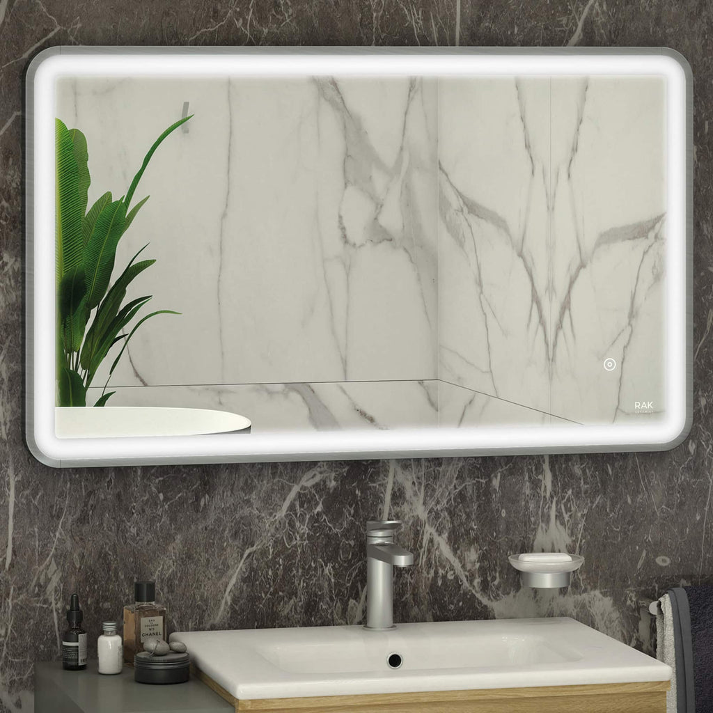 Sleek modern bathroom mirror with LED backlighting and marble wall background, featuring a stylish sink, toiletries, and a lush green plant for a luxurious bathroom aesthetic.