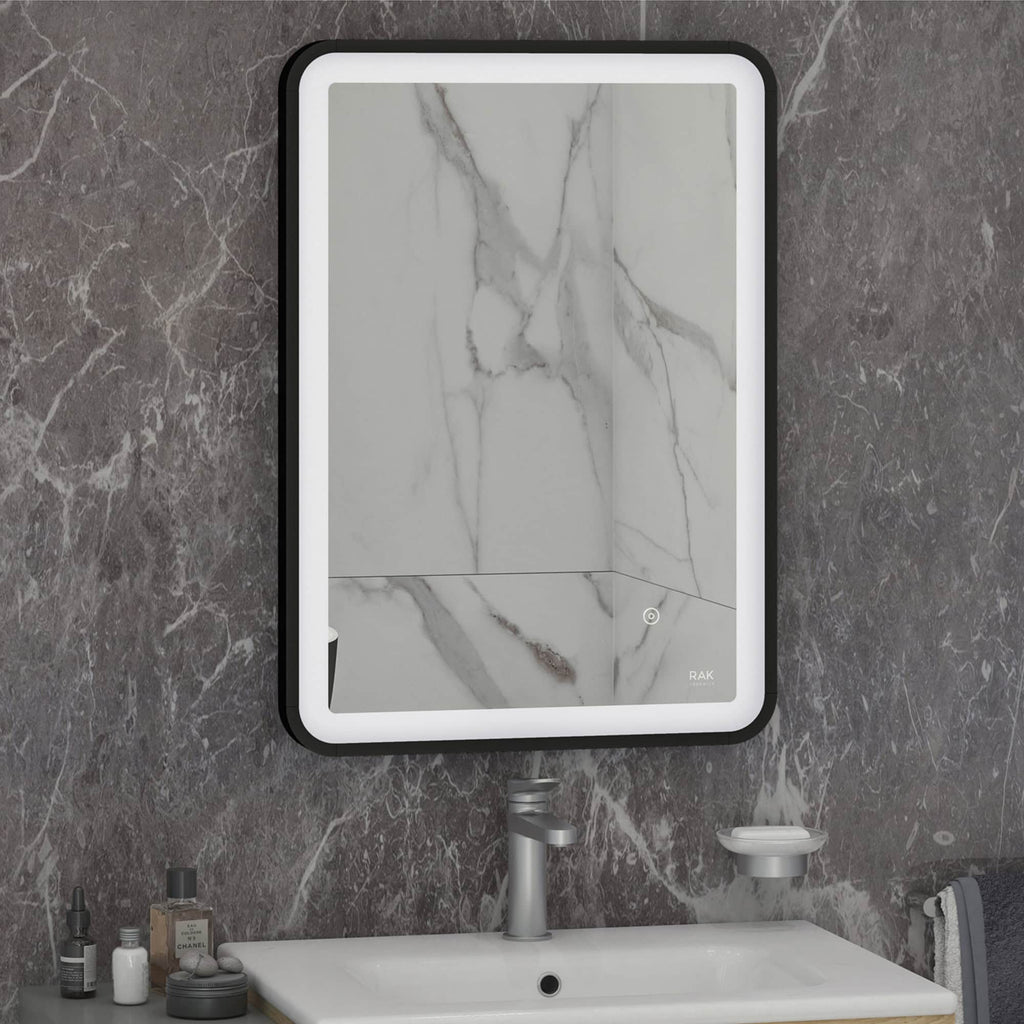 Sleek illuminated bathroom mirror with marble finish wall background, modern wash basin and accessories in contemporary bathroom setting.