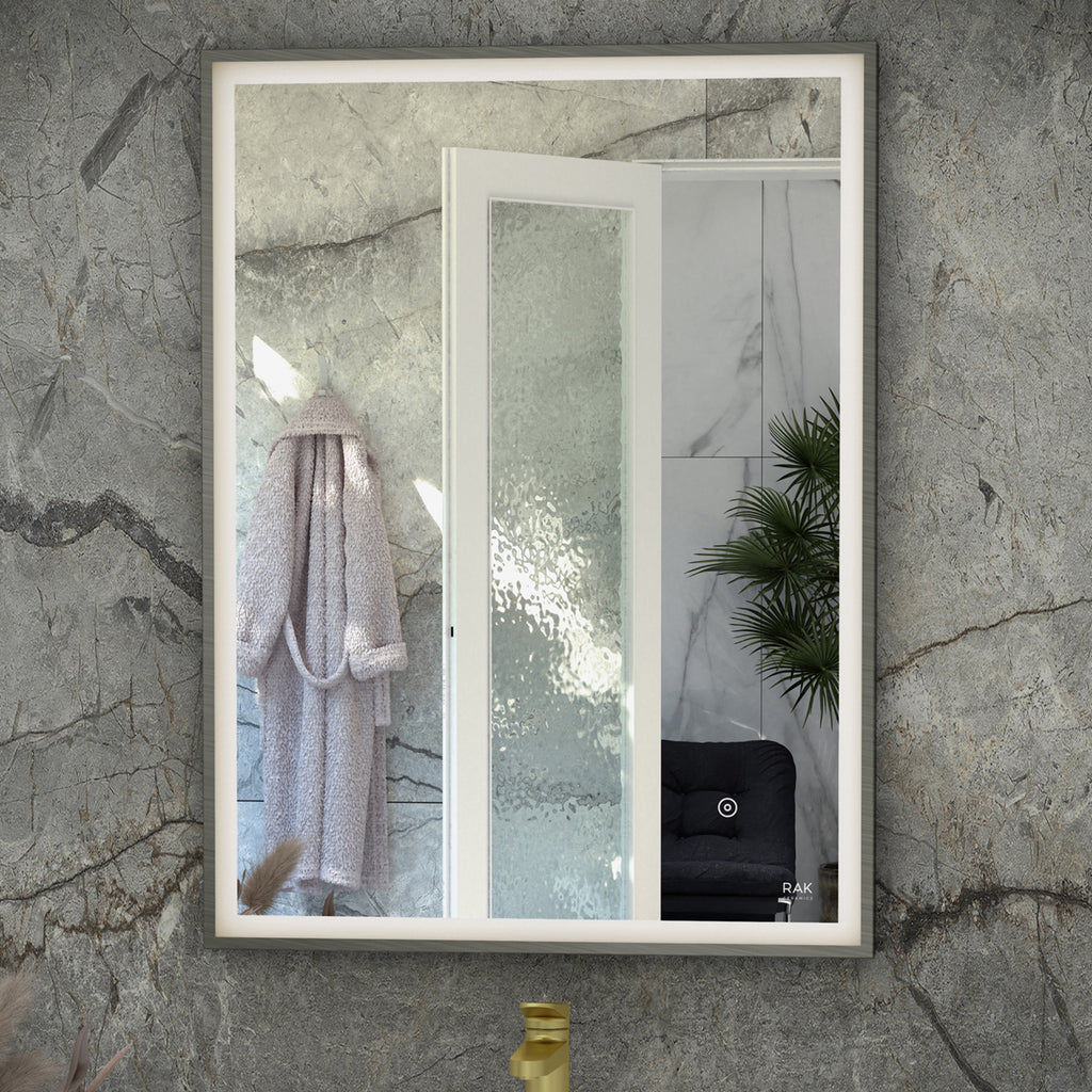 Frameless bathroom mirror with textured wall tiles, frosted glass shower door, white frame, contemporary style, bathroom decor, lush green plant, black seating, elegant interior design, modern bathroom accessories.