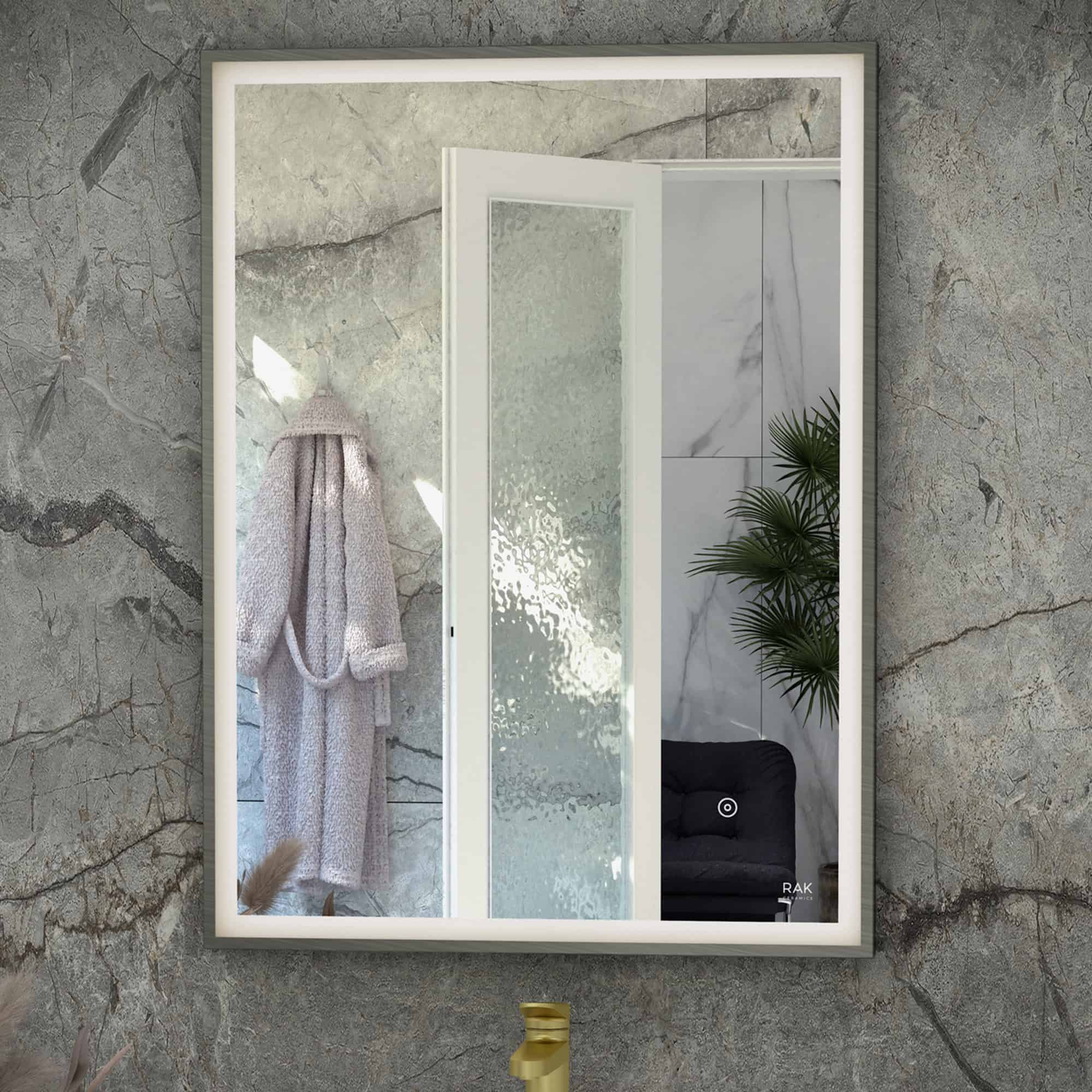 Contemporary bathroom mirror with LED lighting, textured stone wall background, and a hanging cozy bathrobe, showcasing modern bathroom design elements.