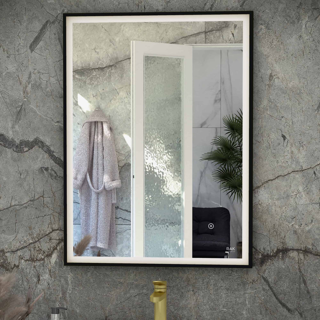 Reflection of a modern bathroom with a textured wall, a white towel on a hook, a frosted glass shower door, and a green plant, showcasing contemporary bathroom design elements.